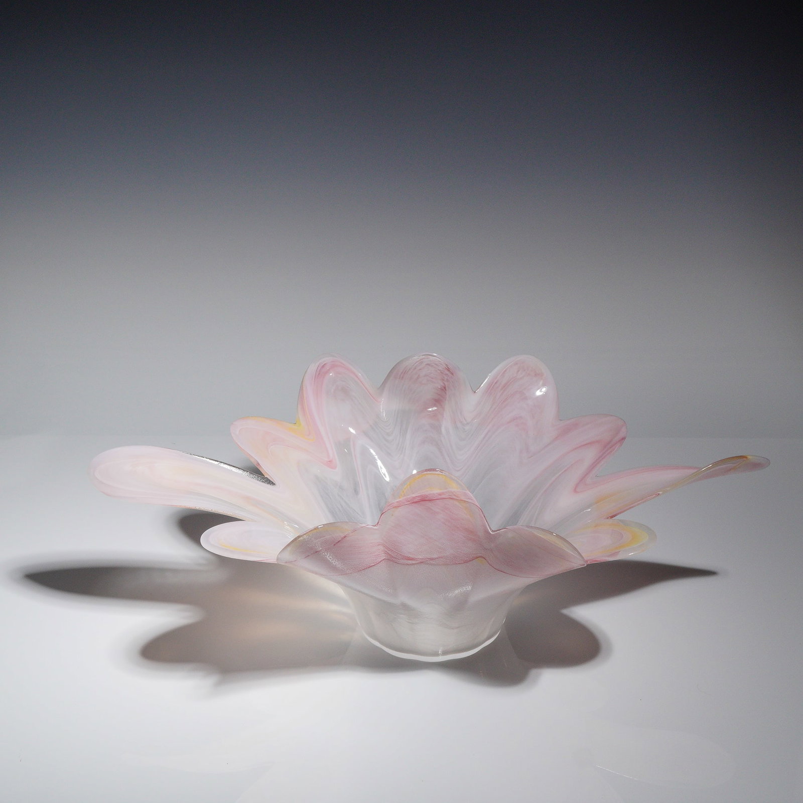 Murano Style Hand-Blown Pink and Yellow Floraform Centerpiece Bowl: A single hand-blown art glass centerpiece bowl or charger, executed in the style of Murano glass. The piece features a dramatic, organic, flared form resembling a stylized eight-pointed flower or star