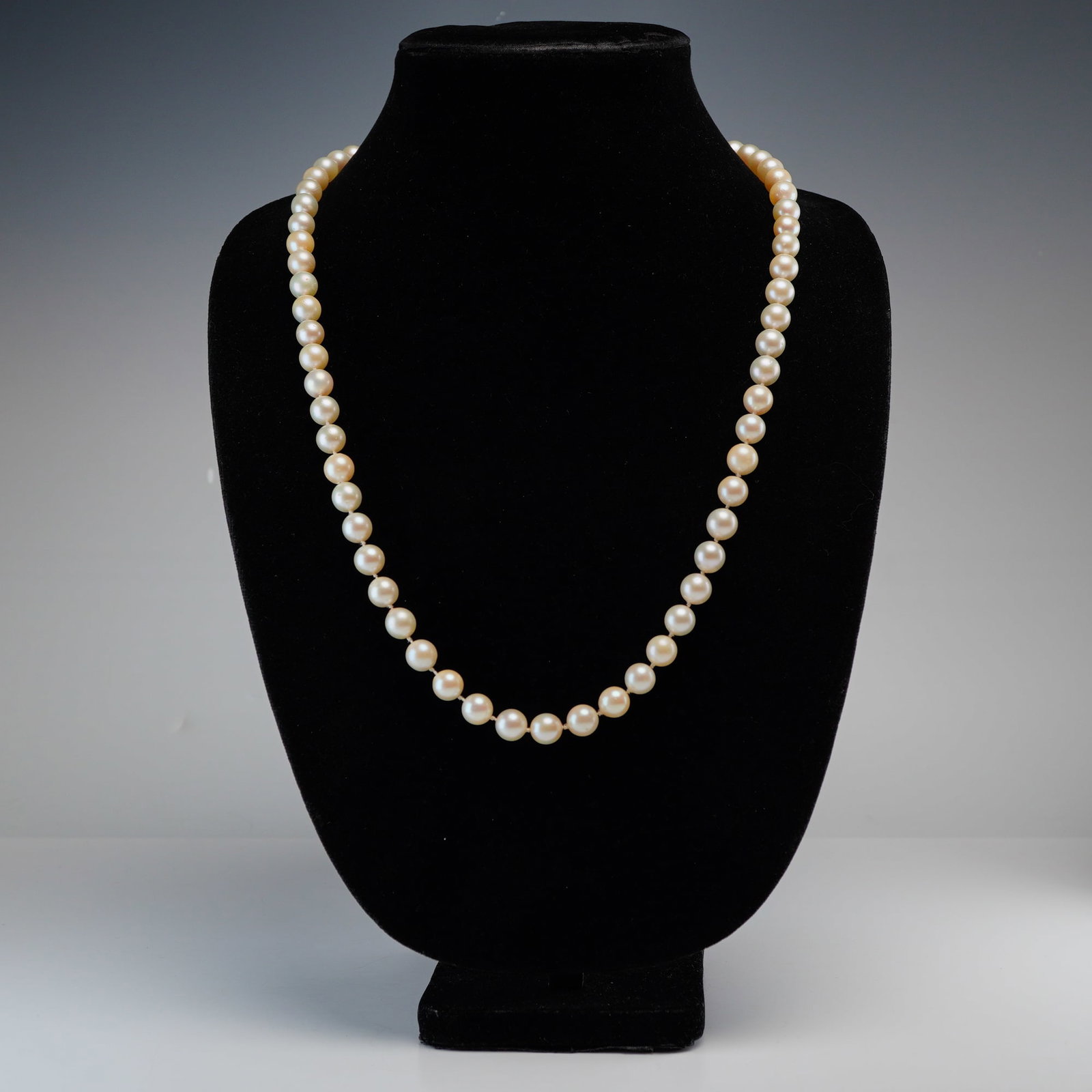 Pearl Single-Strand Hand-Knotted Necklace: A single-strand hand-knotted necklace exhibiting pearls with a creamy-white to light-peach body color with subtle pinkish overtones and good luster. Dimensions16.00"L x 0.50"W Weight76.50g