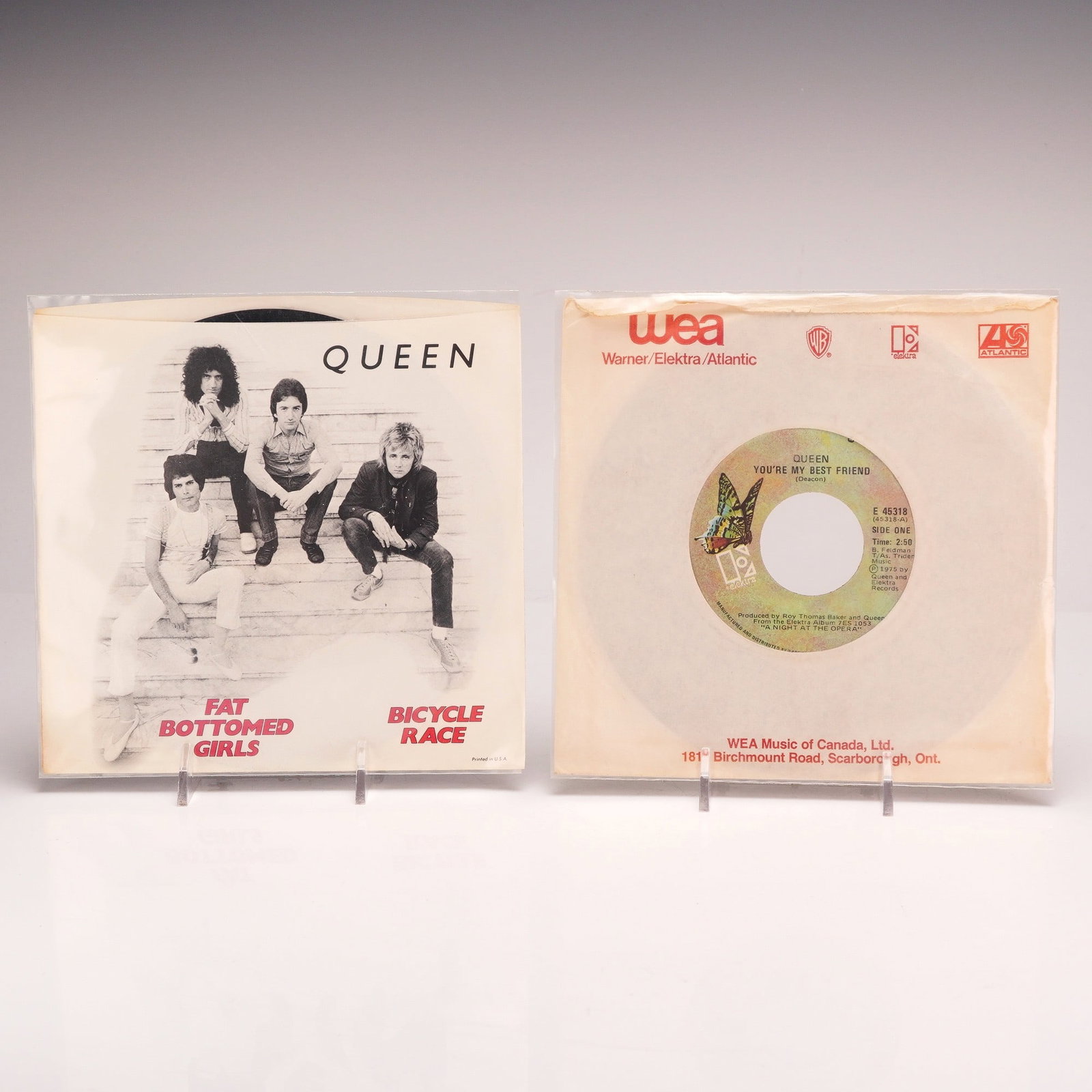 Two Queen 7-Inch Vinyl Records Including Bicycle Race and You're My Best Friend: This lot consists of two 7-inch vinyl records by the rock band Queen, both Canadian pressings released on the Elektra label. Both discs feature the multicolored butterfly label design and were manufac