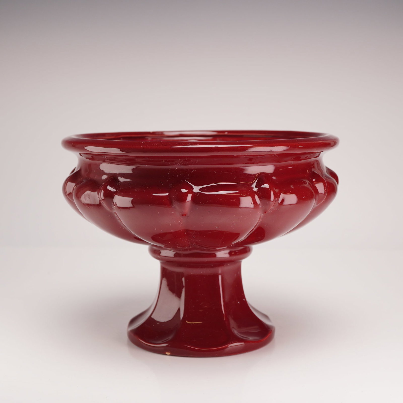 Princess House Pavillion Pattern Opaque Red Glass Pedestal Bowl: An opaque red glass pedestal bowl in the Pavillion pattern, attributed to Princess House. The vessel is constructed of pressed glass with a deep red color. The form features a flared rim above a bulbo