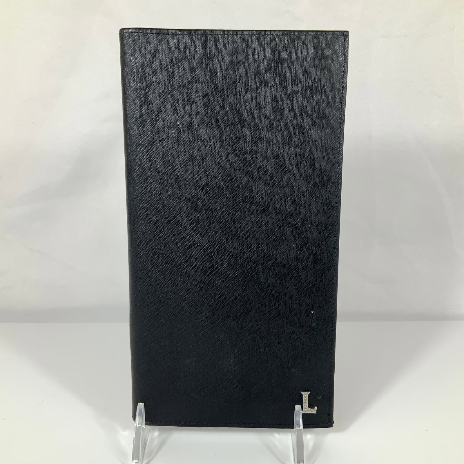 Lancaster Italy Black Textured Leather Long Breast Pocket Wallet: This long-form bifold wallet, also known as a breast pocket or coat wallet, is produced by Lancaster of Italy. It is crafted from black Saffiano-style cross-grain leather, characterized by its texture