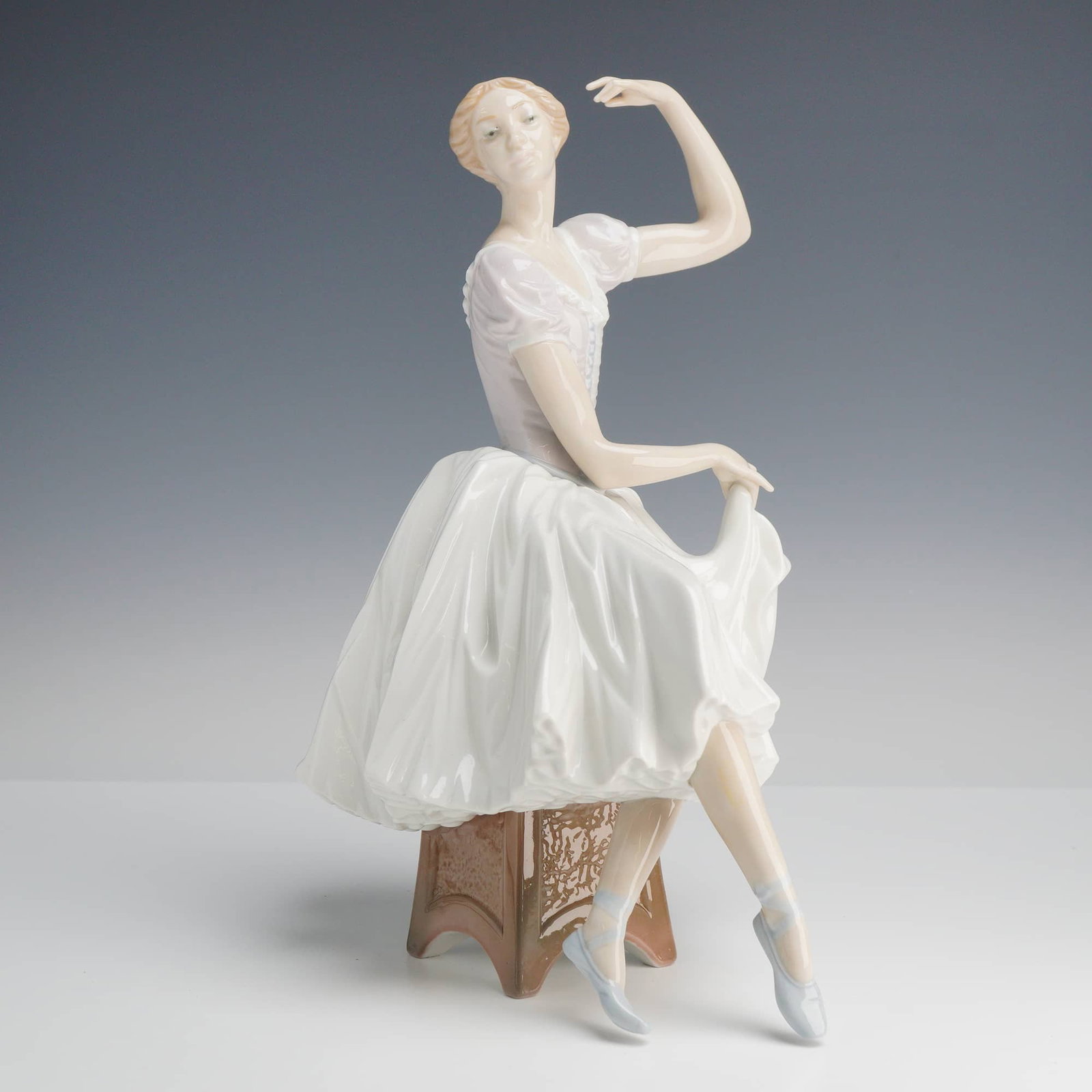 Lladró Weary Ballerina Porcelain Figurine, Model 5275: This Lladró porcelain figurine, identified by the user as the Weary Ballerina and officially titled Zarda or Giselle (Model #5275), is a delicate study of a dancer in repose. Designed by sculptor Sal