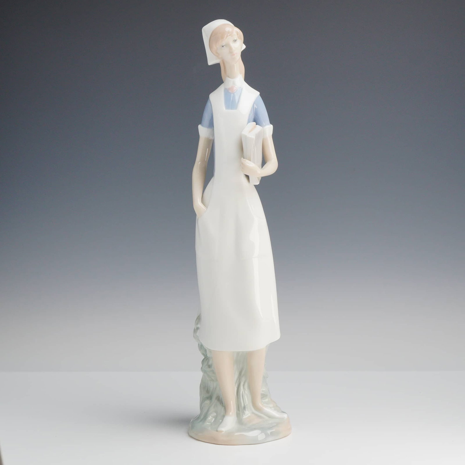 Lladró, Nurse Figurine (Model 4603): A vintage Lladró porcelain nurse sculpture, model number 4603, designed by artist Salvador Furió. This piece was produced in Spain between 1970 and 2003 and is now retired. The figure is rendered in