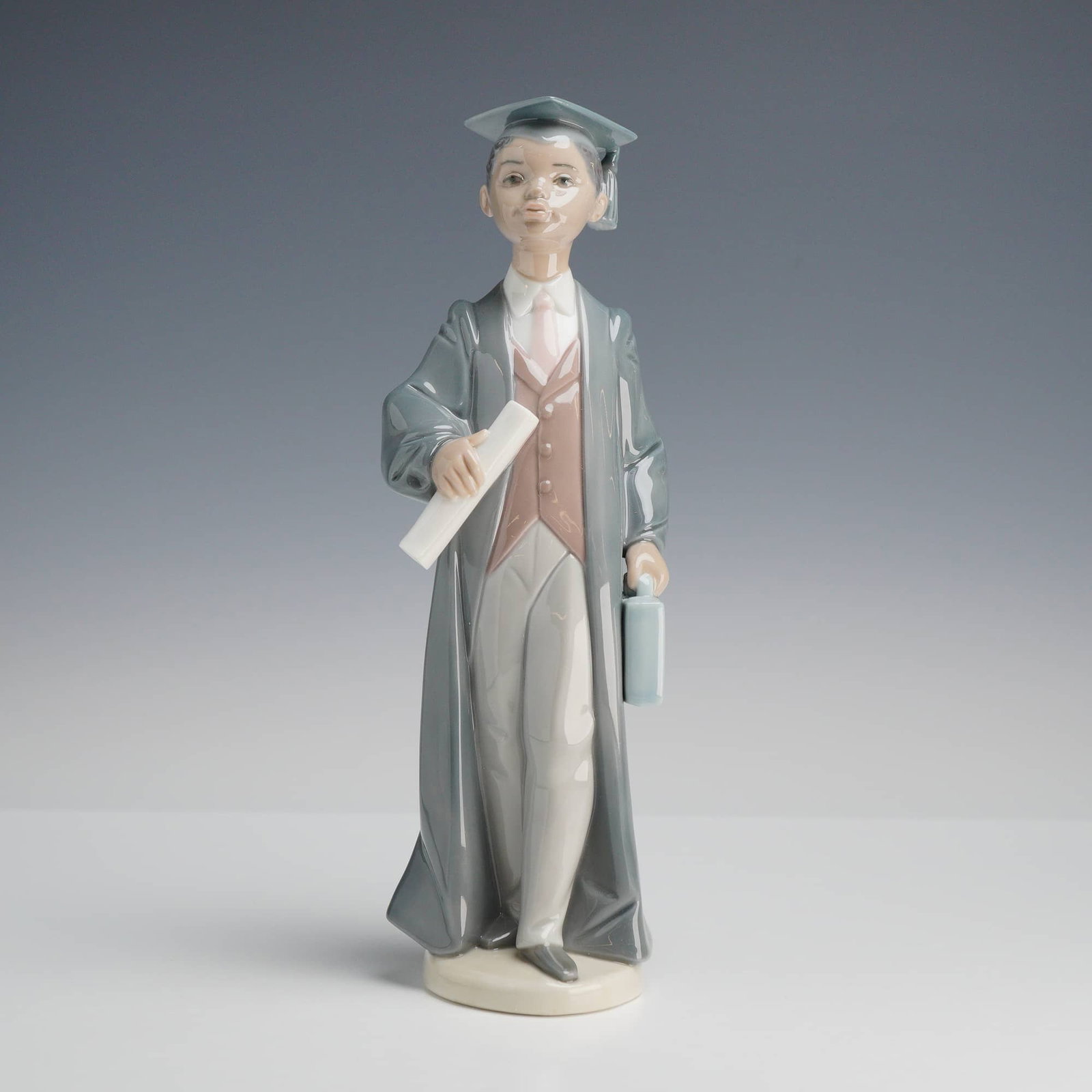 Lladró, Onward and Upward (Model 6494): This fine porcelain figurine, titled Onward and Upward, is a distinguished piece from the Lladró Black Legacy collection. Model number 6494, it depicts a young African American male graduate in full 