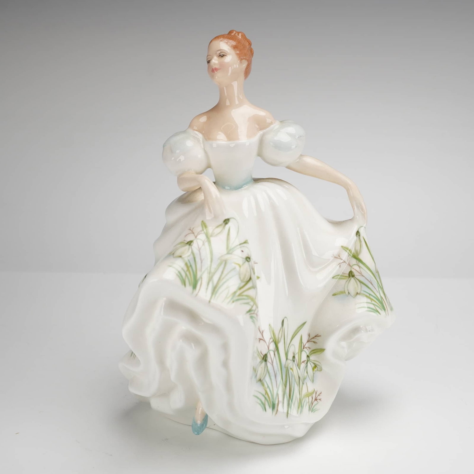 Royal Doulton Bone China Figurine, January HN3341: A Royal Doulton bone china figurine titled January HN 3341 from the Wildflower of the Month collection. This hand-decorated piece was modeled by Peggy Davies and is dated 1991. The figure is depicted