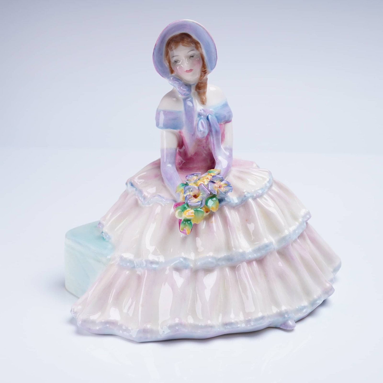 Royal Doulton Figurine Daydreams HN 1731: A glazed porcelain figurine manufactured by Royal Doulton, titled "Daydreams," model number HN 1731. The figurine depicts a seated woman modeled in a mid-20th-century romantic style. The figure is exe
