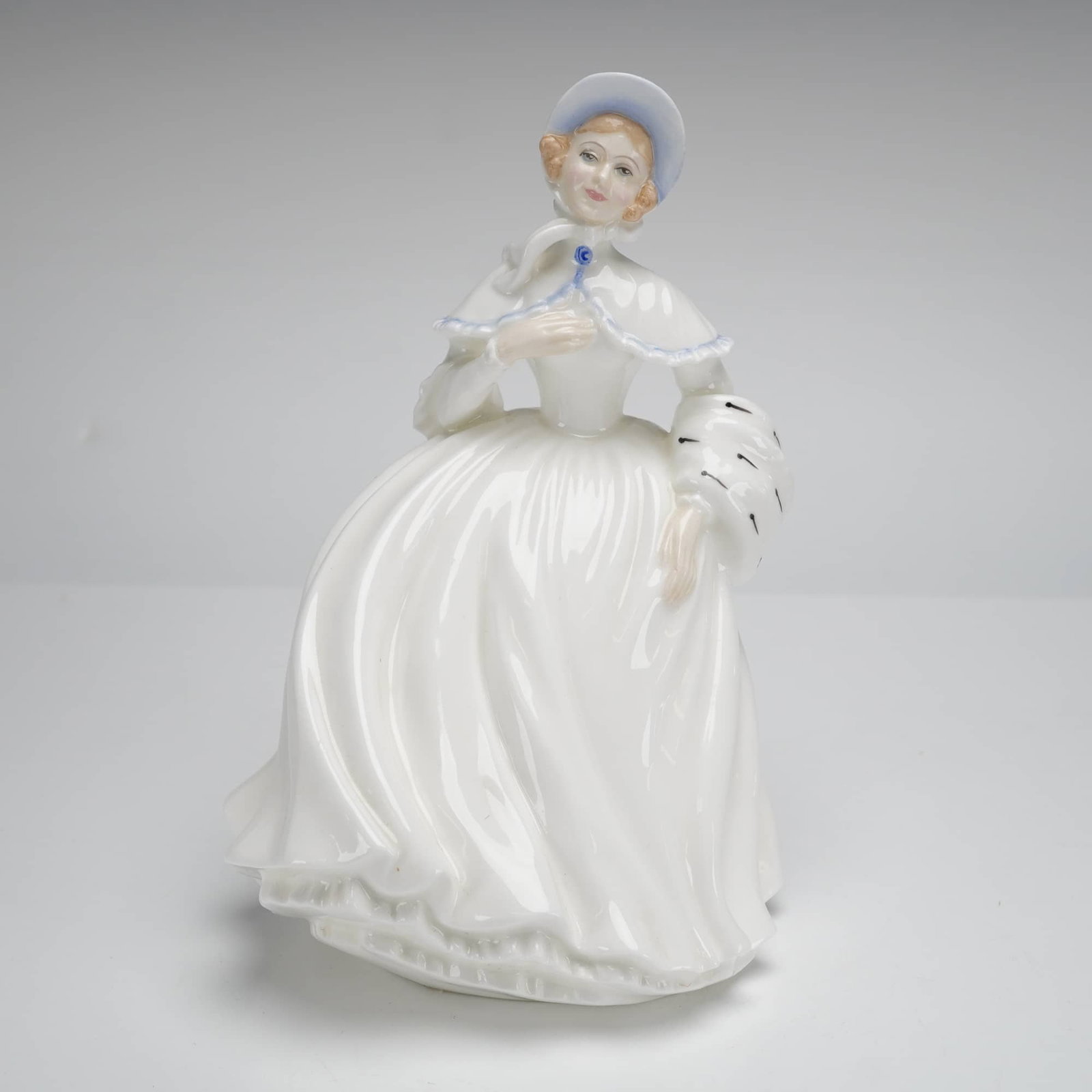 Royal Doulton Figurine, Jessica HN 3497: A glazed bone china figurine by Royal Doulton, titled 'Jessica' (HN 3497) and modeled by Peggy Davies. The piece depicts a young woman in a period costume consisting of a voluminous white gown, a matc