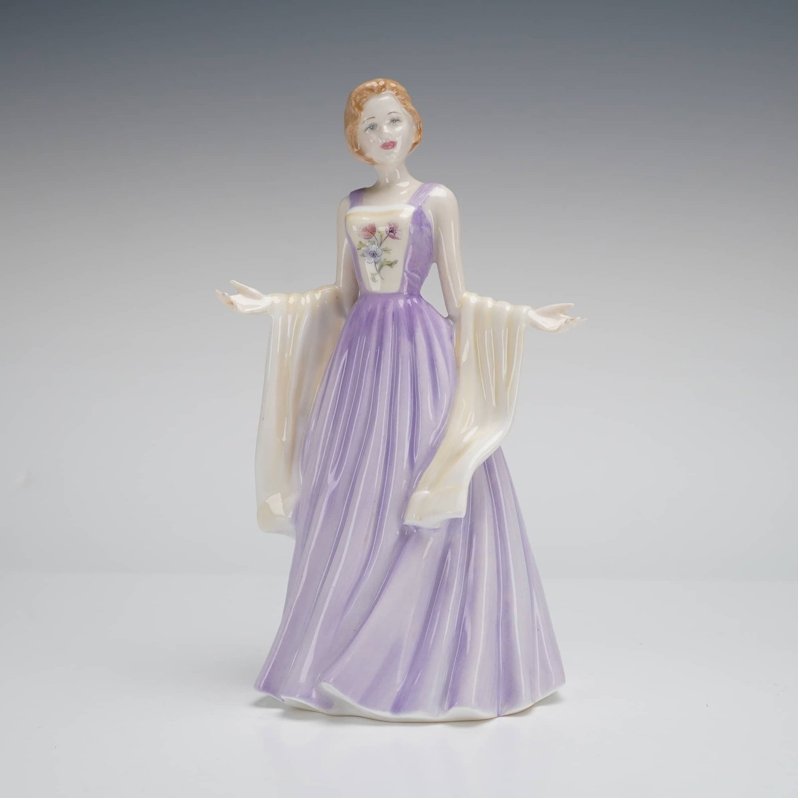 Royal Doulton Figurine, Julia HN 4390: A glazed porcelain figurine titled 'Julia' (HN 4390) from the Royal Doulton Classics collection. The piece depicts a woman with reddish hair wearing a flowing lavender evening gown. The bodice feature