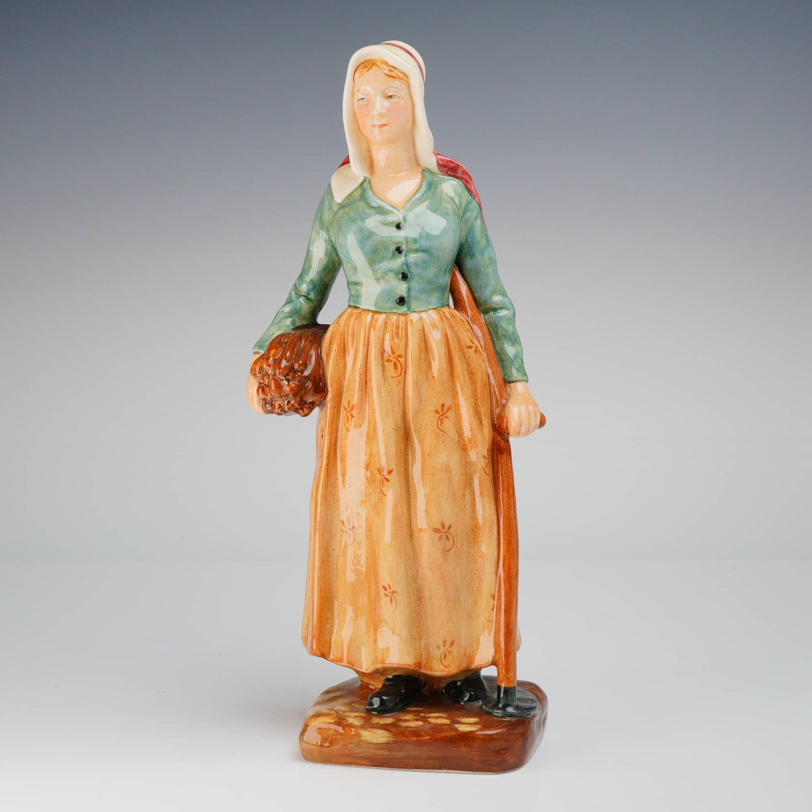 Royal Doulton French Peasant HN2075 Figurine: A single Royal Doulton Figurine, French Peasant HN2075, is a ceramic figure colored orange, green, and white, marked COPR. 1950. Dimensions: 3.50"L x 2.50"W x 9.25"H Weight: 15.00oz