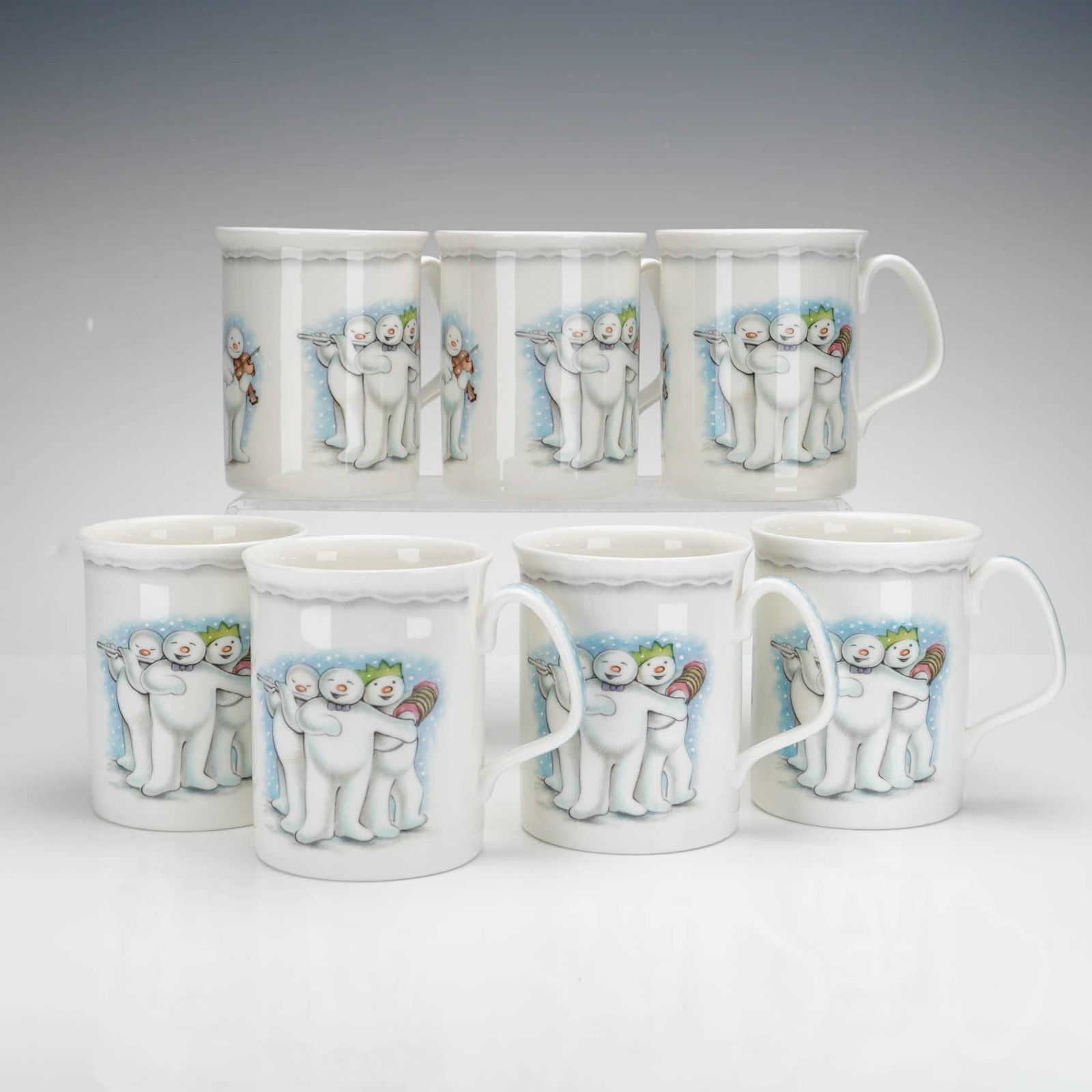 7pc Royal Doulton Bone China Mugs, Snowman Band: A set of seven Royal Doulton bone china mugs from The Snowman Gift Collection, featuring various colorful illustrations based on the classic Raymond Briggs story. The mugs depict scenes of the Snowman