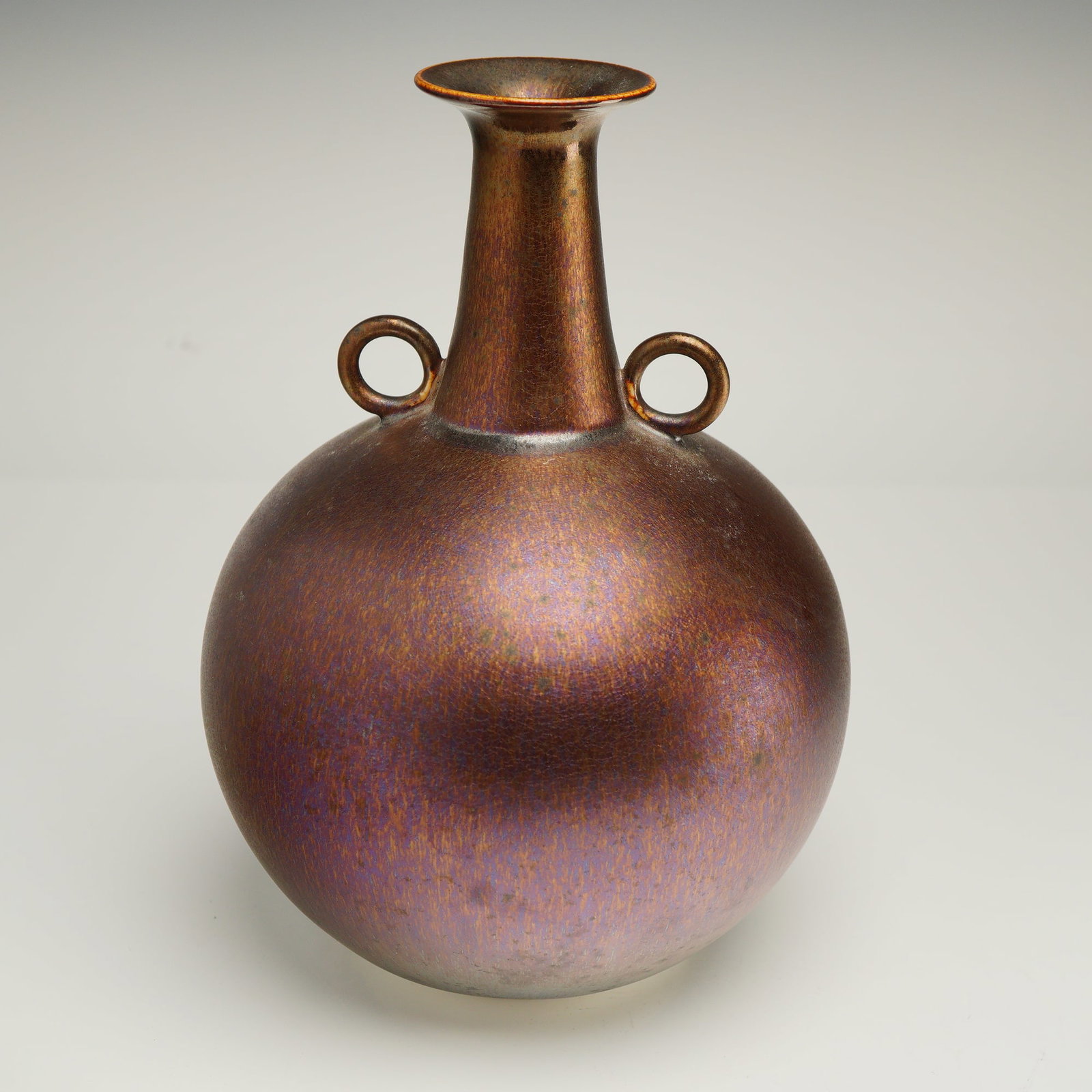 Hideaki Miyamura Studio Art Pottery Iridescent Luster Vase: A studio art pottery bottle-form vase by Hideaki Miyamura b. 1955. Featuring a globular body, tall neck, and applied loop handles at the shoulder. The surface is finished in a satin glaze with an irid