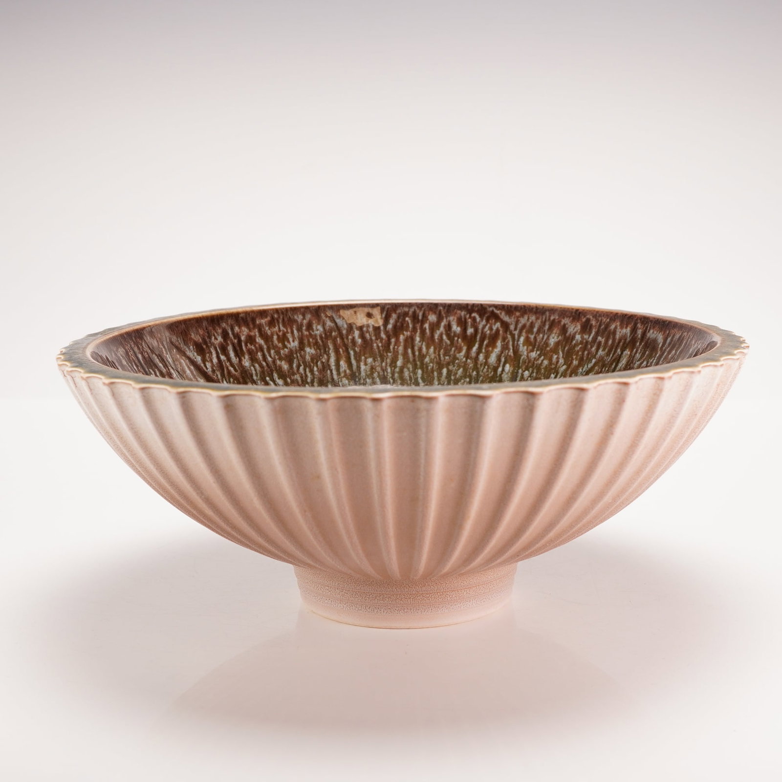 Wedgwood Norman Wilson Fluted Bowl: This studio-style ceramic bowl was designed by Norman Wilson for Wedgwood, produced in England during the mid-20th century. The shallow circular form features a tapered body with a finely fluted exter