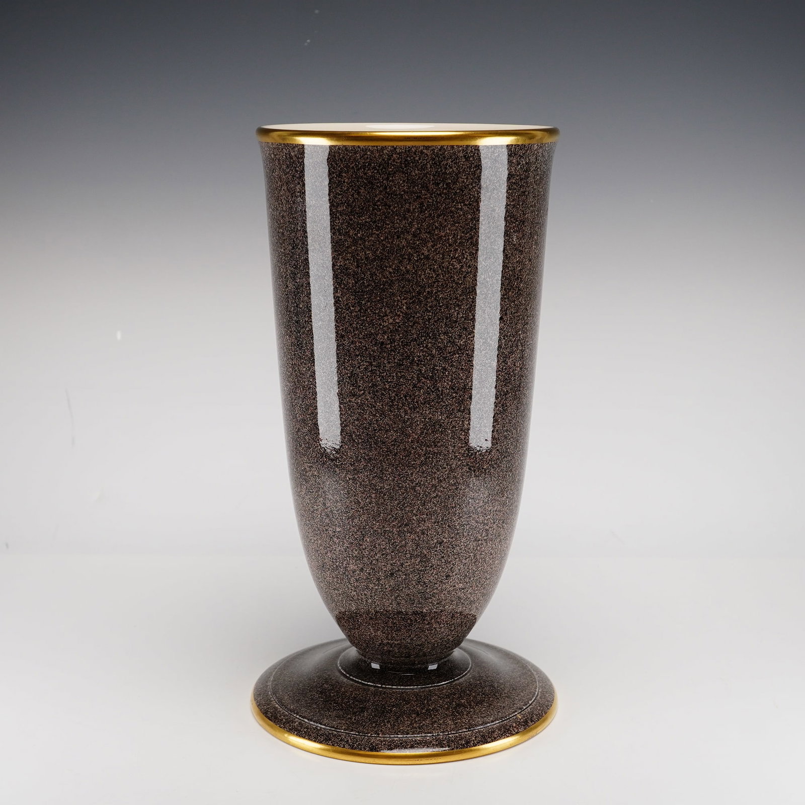 Wedgwood of Etruria and Barlaston Vase: A Wedgwood pedestal vase. The vessel is of flared cylindrical form, tapering to a narrow waist and supported by a spreading circular foot. The exterior is finished in a high-gloss, finely stippled gla