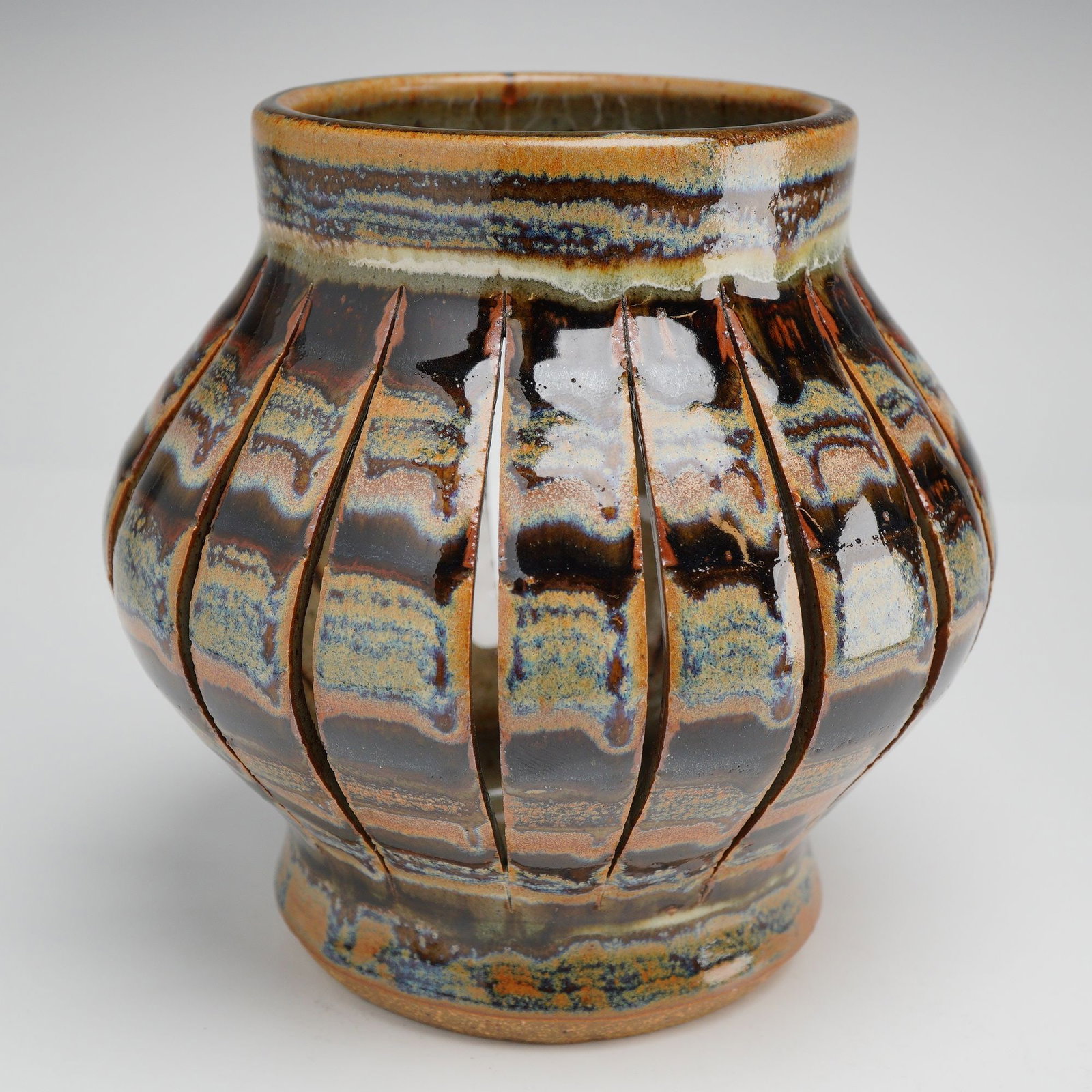 Michael Rutkowsky Studio Pottery Pierced Stoneware Lantern Vessel: A contemporary studio pottery stoneware vessel by North Carolina artist Michael Rutkowsky. This hand-thrown piece features a bulbous, lantern-like form characterized by numerous vertical linear cutout