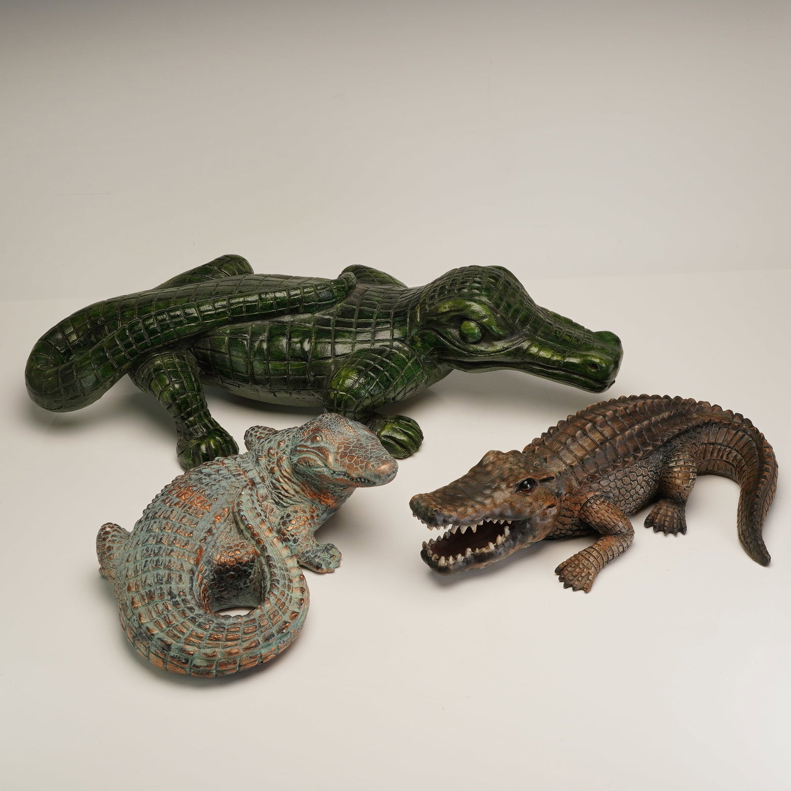Three Sea Creations and Contemporary Ceramic Alligator Sculptures: This set of three ceramic alligator and crocodile sculptures includes a variety of decorative finishes. The largest piece is a stylized crocodile in the manner of Sea Creations, featuring a high-gloss