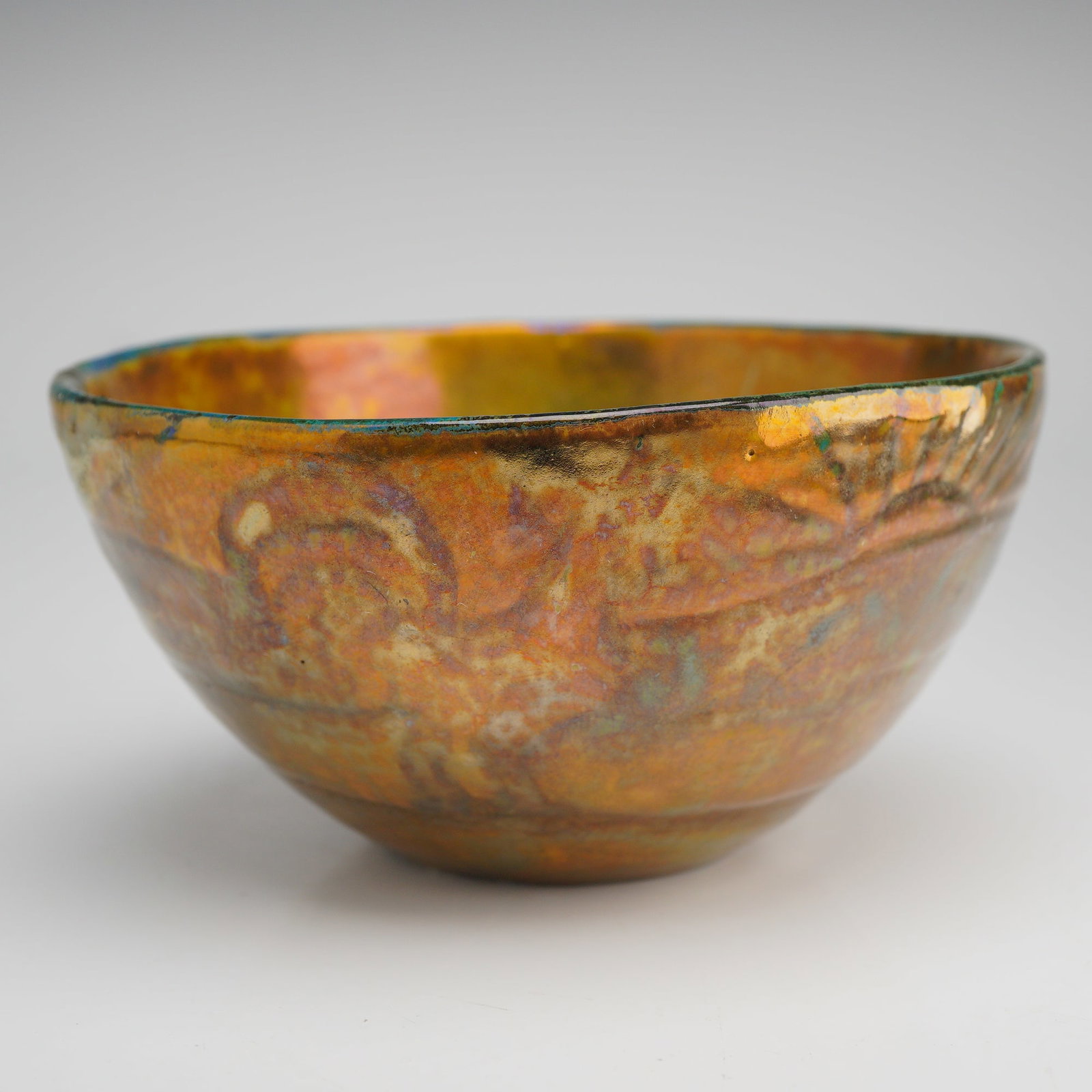 Pewabic Pottery Iridescent Reduction Glaze Bowl: A ceramic vessel produced by Pewabic Pottery of Detroit, Michigan, featuring a heavy iridescent reduction glaze. The bowl is hand-thrown or molded with a subtle, low-relief band of repeating stylized