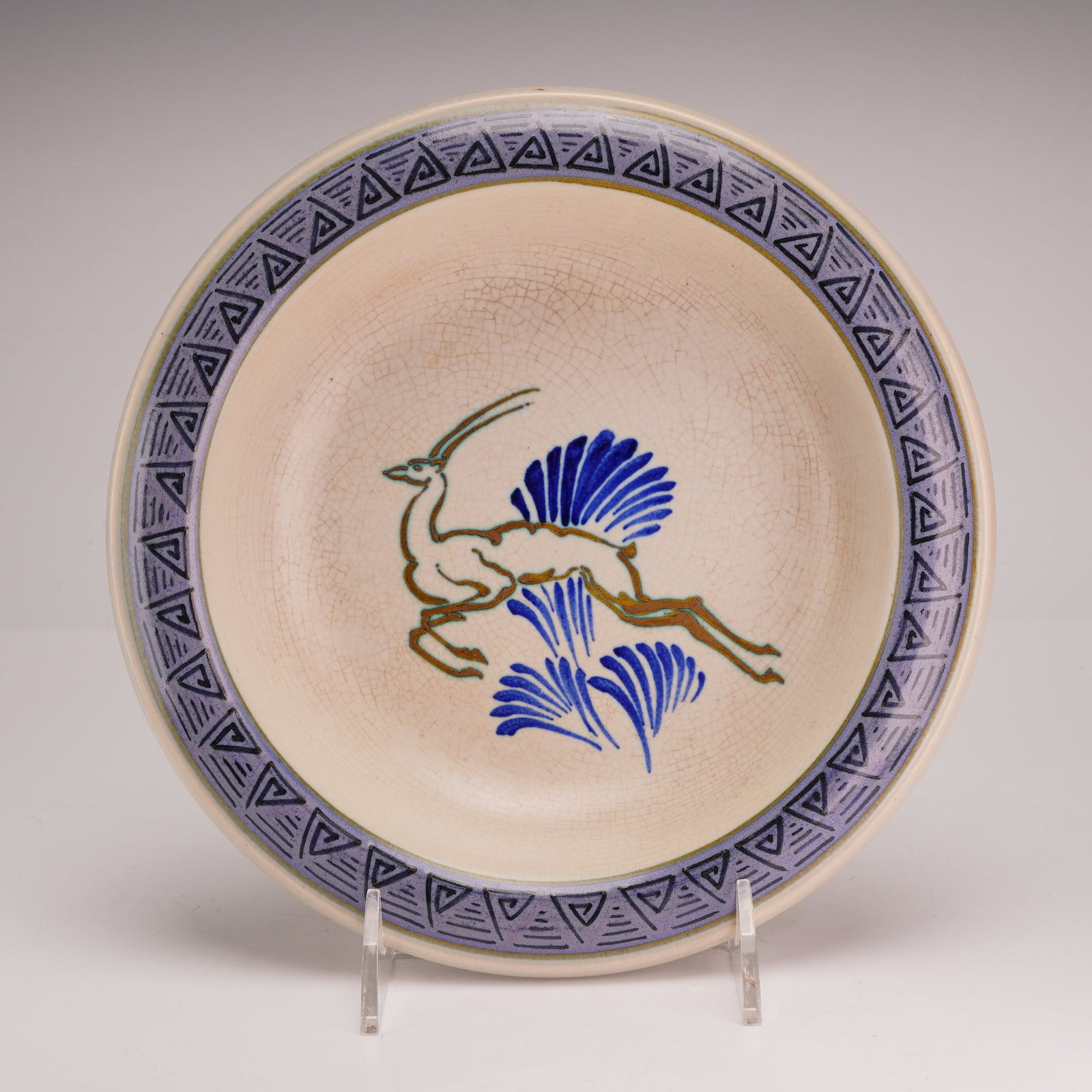 Gouda Plateelbakkerij Zuid-Holland Art Deco Earthenware Gazelle Plate: This Dutch Art Deco earthenware plate is a product of the Plateelbakkerij Zuid-Holland factory, as indicated by the hand-painted marks on the underside. The central decoration features a stylized leap