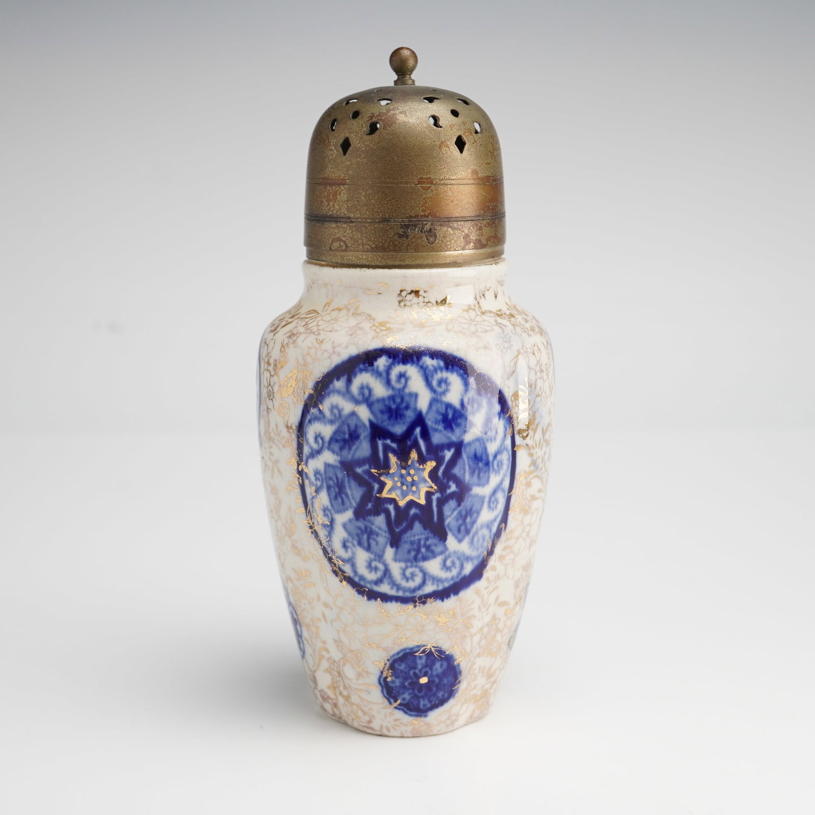 J. K. L. Fenton England, Osaka Pattern, Sugar Shaker: An antique ceramic sugar shaker produced by J. K. L. Fenton of Fenton, England, featuring the Aesthetic Movement Osaka pattern. The earthenware body is decorated in a striking blue and white transfer-