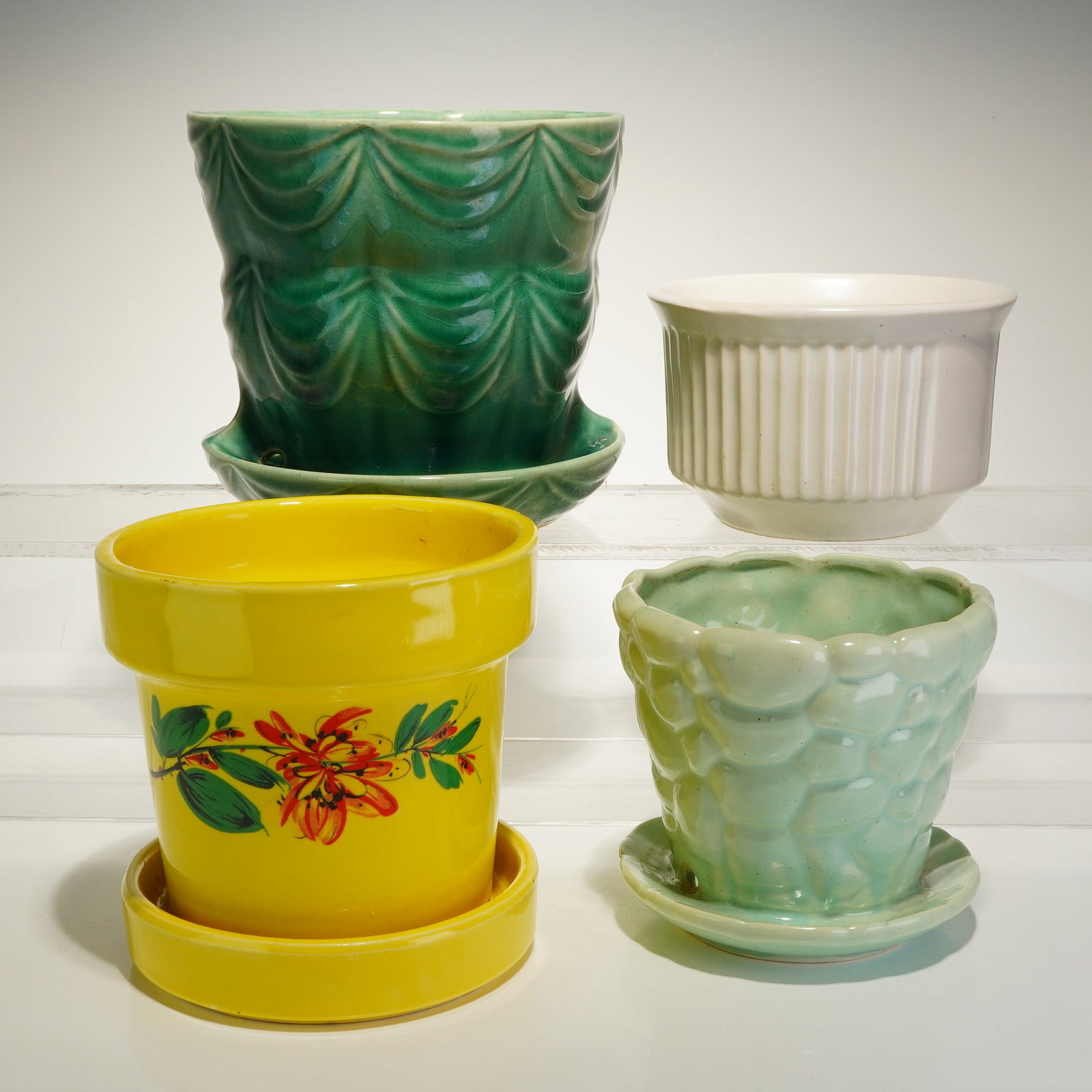 4pc McCoy Pottery and Brush Pottery Planters & Bowls: This 4pc ceramic collection features planters and bowls produced by McCoy Pottery and Brush-McCoy Pottery. The largest item is a dark green glazed pot with an attached saucer and a draped curtain