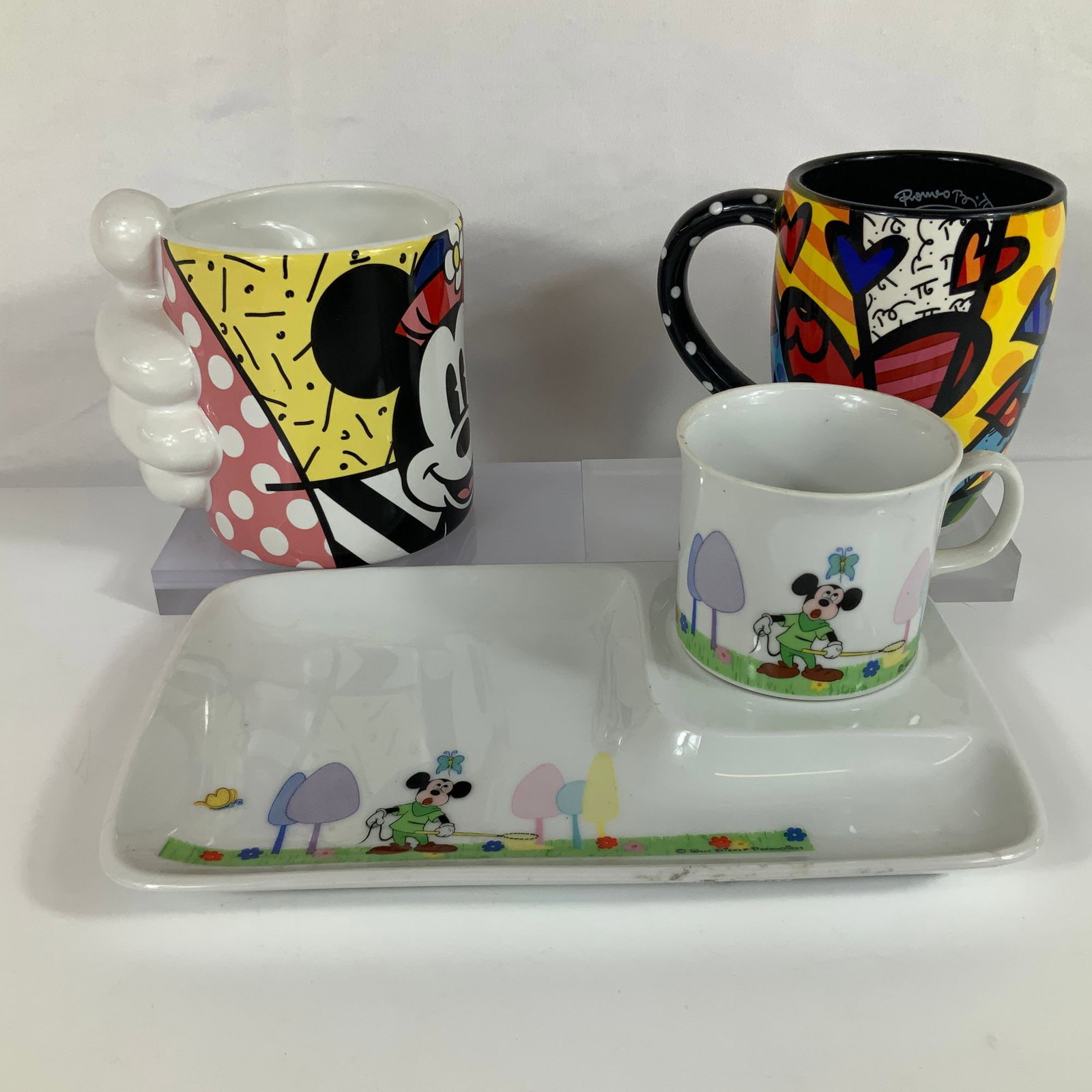 A Collection of Disney Ceramic Tableware Including Romero Britto Mugs and a Vintage Snack Set (1 of 3)