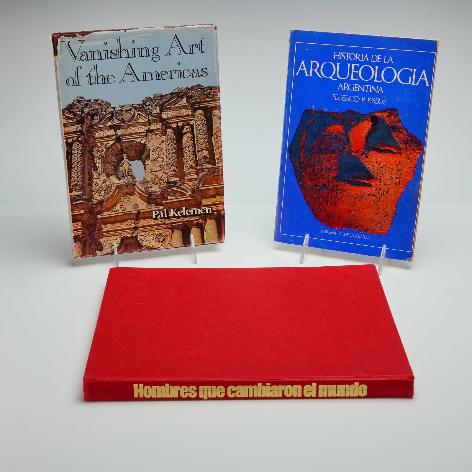 3 Books on Art History, Archaeology, and Men Who Changed the World: A group of three books comprising English and Spanish languages focused on art history, archaeology, and biography. The collection includes Vanishing Art of the Americas by Pal Kelemen, published in 1