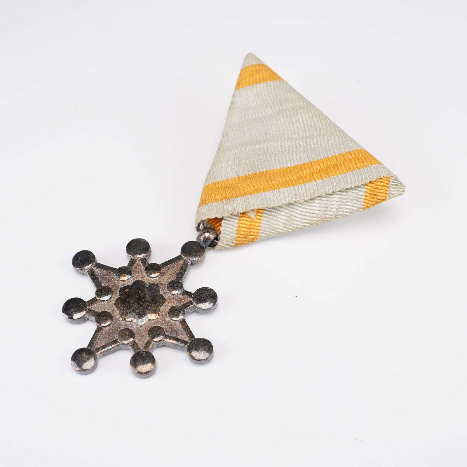 Japanese Order of the Sacred Treasure Medal in Presentation Case: Japanese Order of the Sacred Treasure medal, housed in its original fitted presentation case lined in rich purple silk. The medal features its traditional silvered, multi-pointed star form with