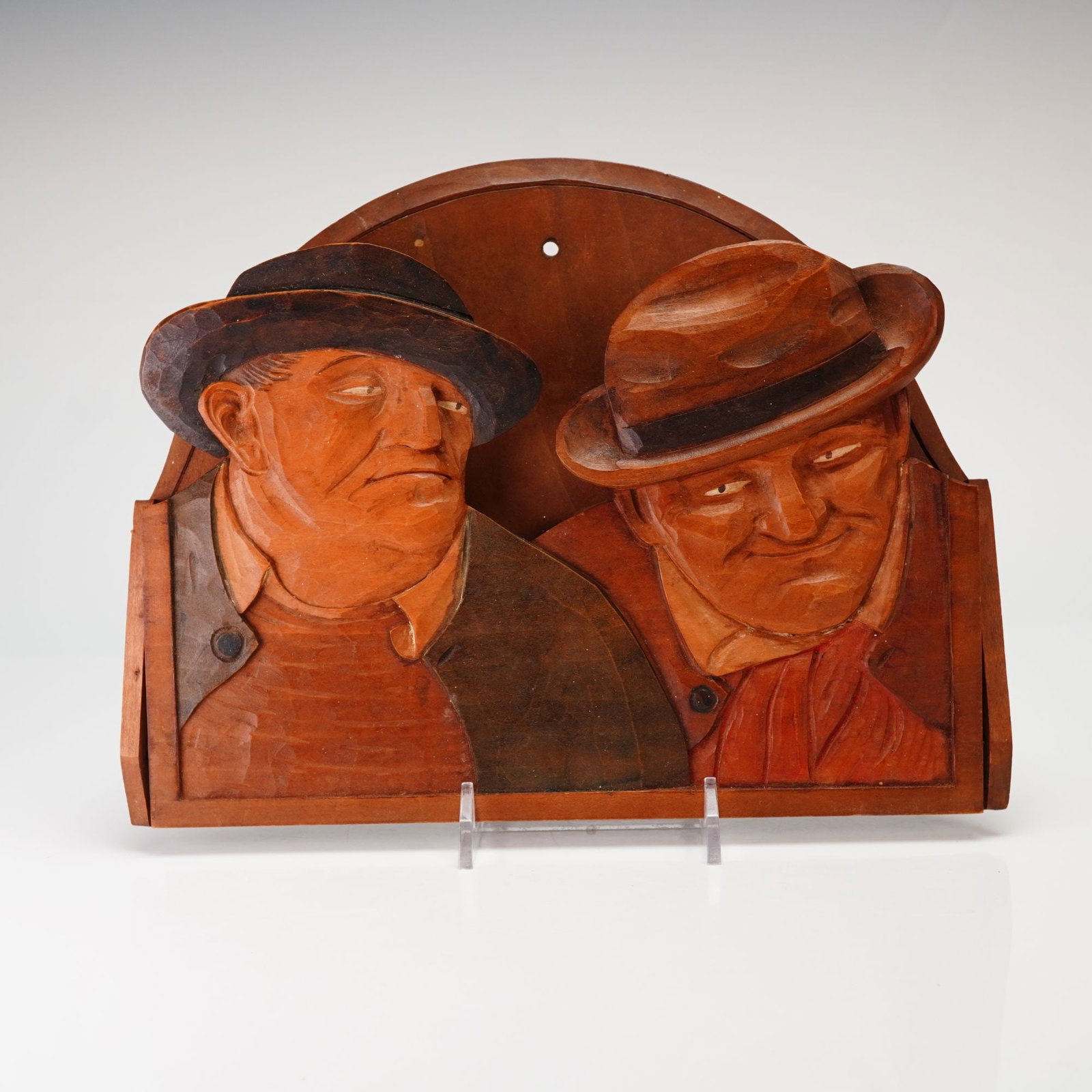 Carvel Wood Wall Hanging Depicting Two Men: This Carvel Wood wall hanging or letter holder features a high relief carving of two men wearing hats with caricature-like facial expressions. The piece is constructed from wood with various stains an