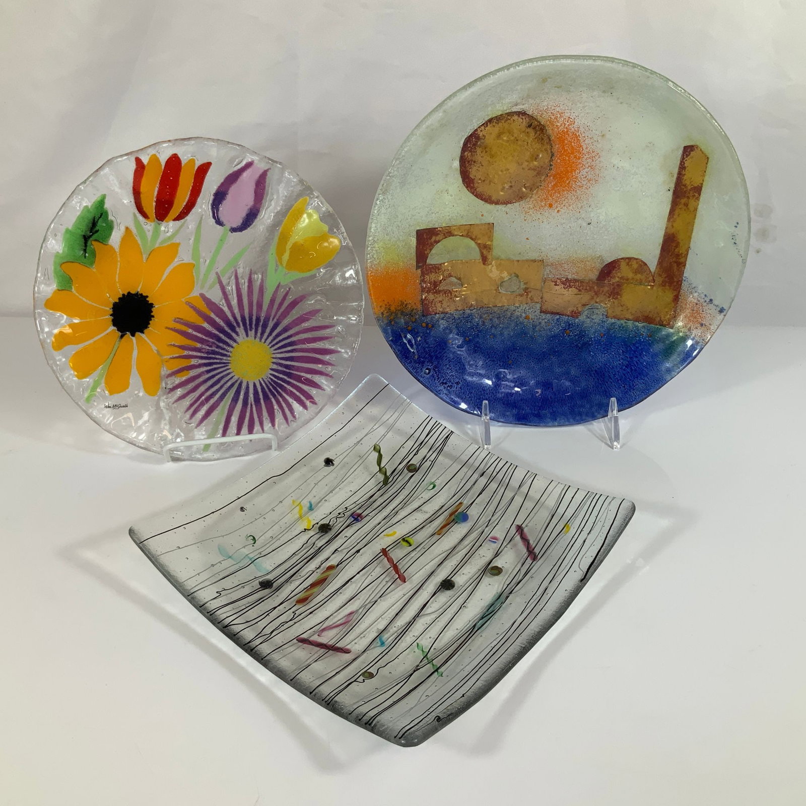 Three Contemporary Fused and Slumped Art Glass Plates Including William McGrath: This lot consists of three contemporary studio glass plates featuring various fused and slumped glass techniques. The first is a circular plate by William McGrath for Fusion Art Glass in the Summer Ga