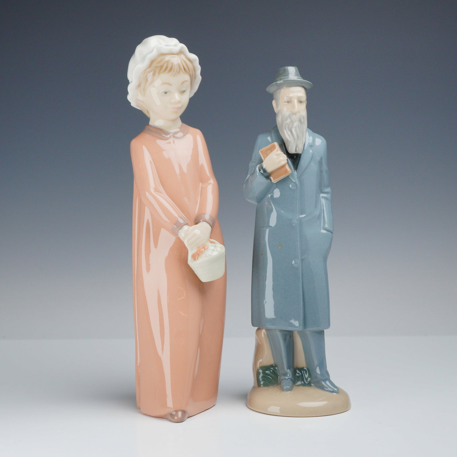 Two Zaphir and Nadal Spanish Polychrome Glazed Porcelain Figurines: This lot consists of 2 figurines made of polychrome glazed porcelain in the style of late 20th century Spanish ceramic artistry. The first figurine is a Zaphir porcelain figure of a young woman in a l