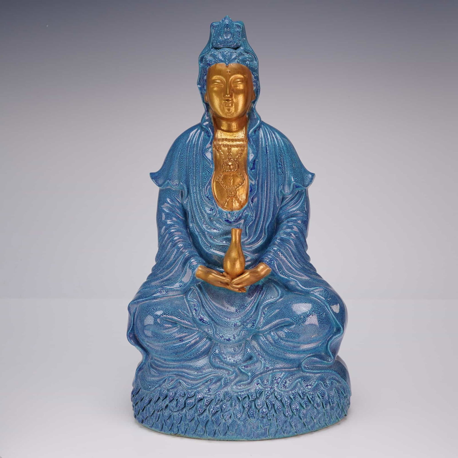 Robins Egg Blue and Gilt Porcelain Seated Guanyin: A porcelain sculpture of a seated Guanyin, finished with a robin's egg blue glaze and gilt accents. Dimensions6.5"L x 4.5"W x 12.25"H Weight4.13 lb