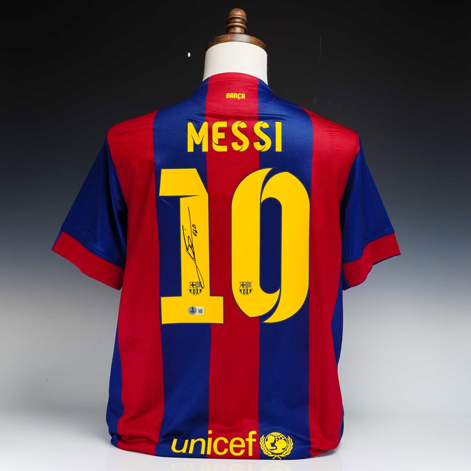 Signed Lionel Messi FC Barcelona Nike Home Jersey with Authentication: This sports memorabilia item is a Nike brand FC Barcelona home jersey featuring the club's traditional red and blue vertical stripes. The front of the jersey displays a yellow embroidered Nike swoosh