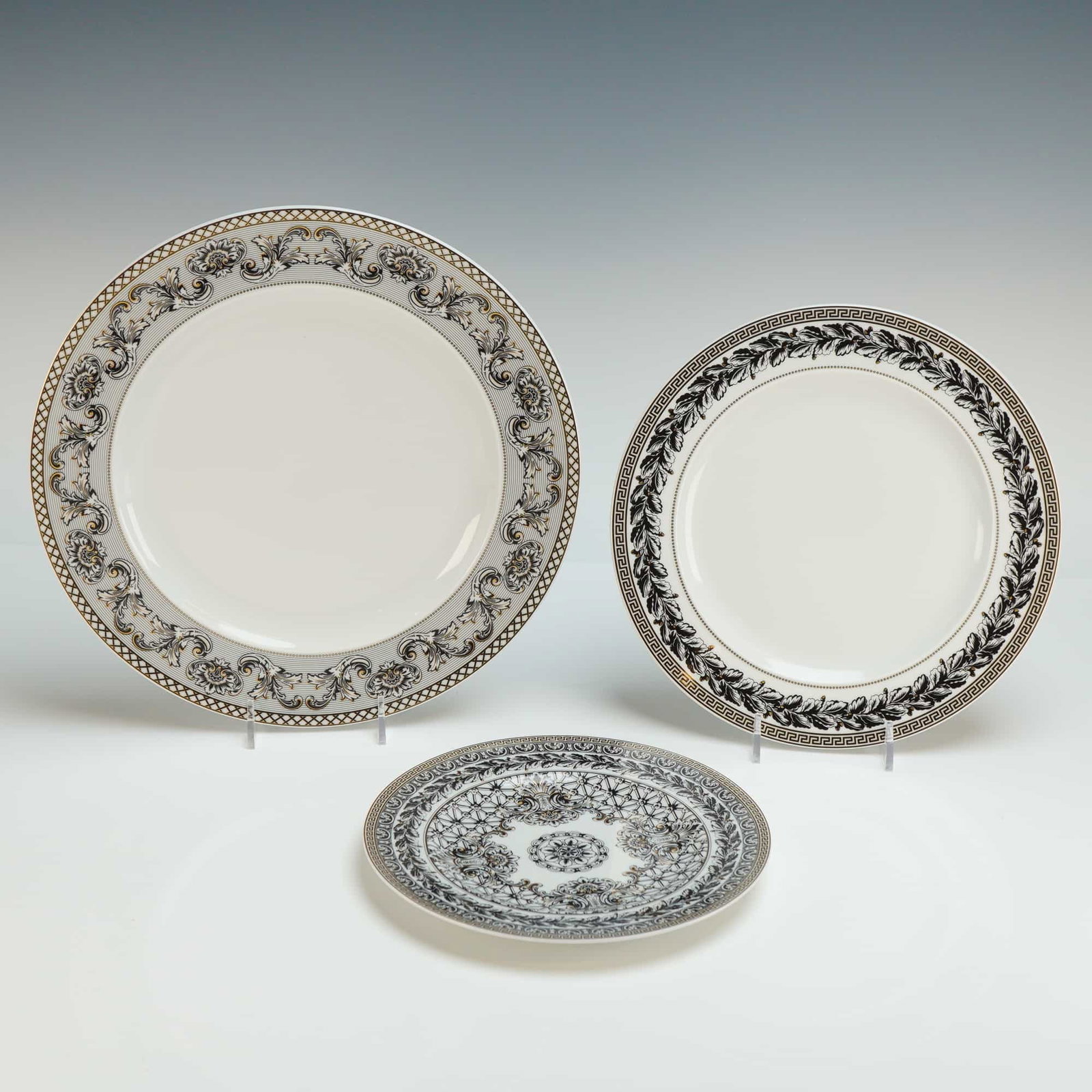 3pc Versace Rosenthal Porcelain Plate Set, Marqueterie: This elegant three-piece porcelain plate set by Versace for Rosenthal features the striking Marqueterie pattern, a signature design that combines classical motifs with bold, contemporary flair. The