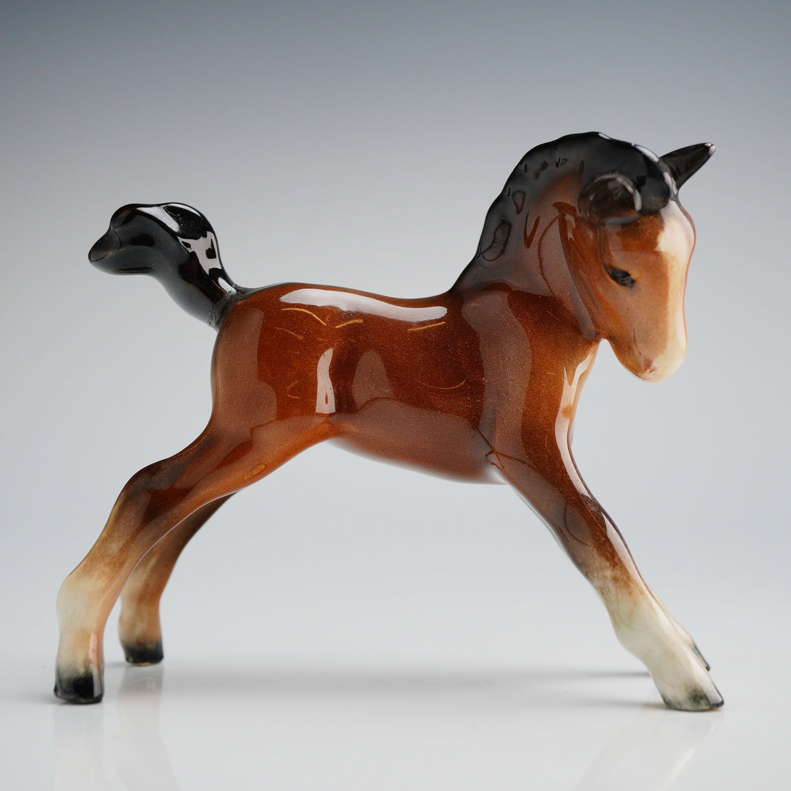 Beswick Porcelain Foal Figurine: A single ceramic figurine attributed to Beswick, England, commonly identified as Model 996, depicting a young horse (foal). The piece is executed in a naturalistic style with a high-gloss glaze finish
