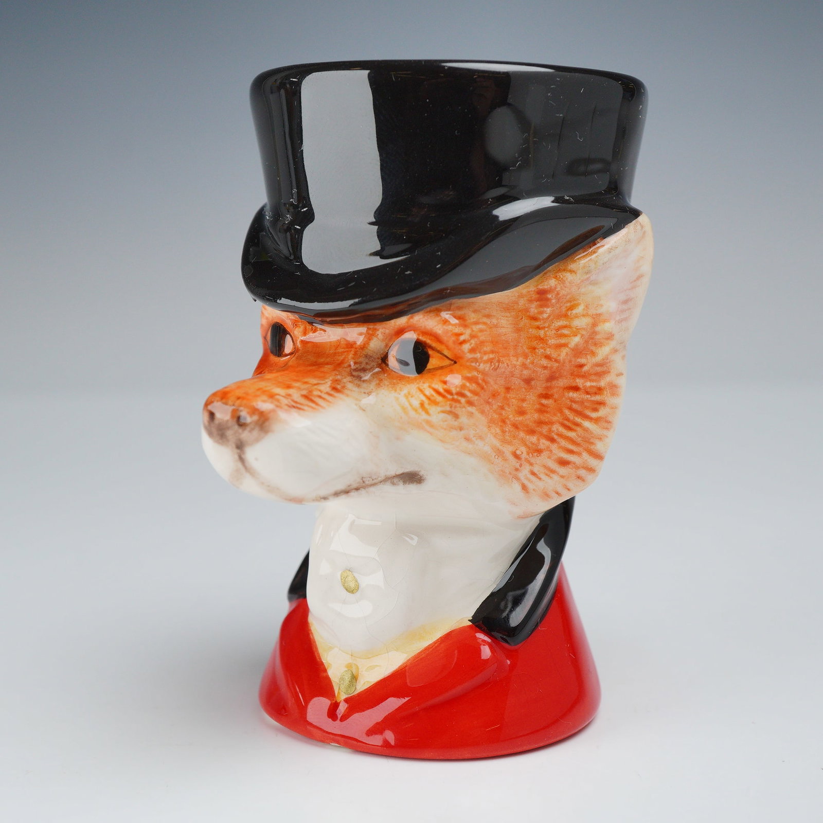 Border Fine Arts Studio Lord Reynard Fox Ceramic Egg Cup: A molded ceramic egg cup from the Border Fine Arts Studio collection, identified as the Lord Reynard model. The piece is designed as an anthropomorphic fox head wearing a black top hat, which serves a
