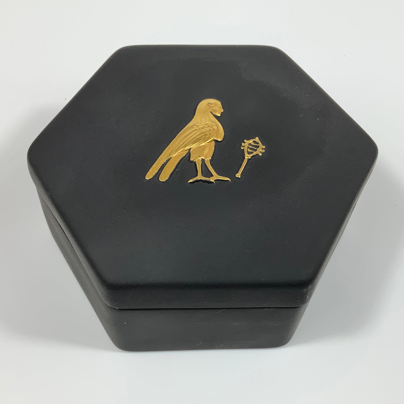 Wedgwood Gilded Black Basalt Egyptian Hexagonal Lidded Trinket Box: This Wedgwood black basalt and jasperware trinket box is designed in a hexagonal form with a flush-fitting lid. The item is crafted from matte, fine-grained black stoneware. The lid features a gilded