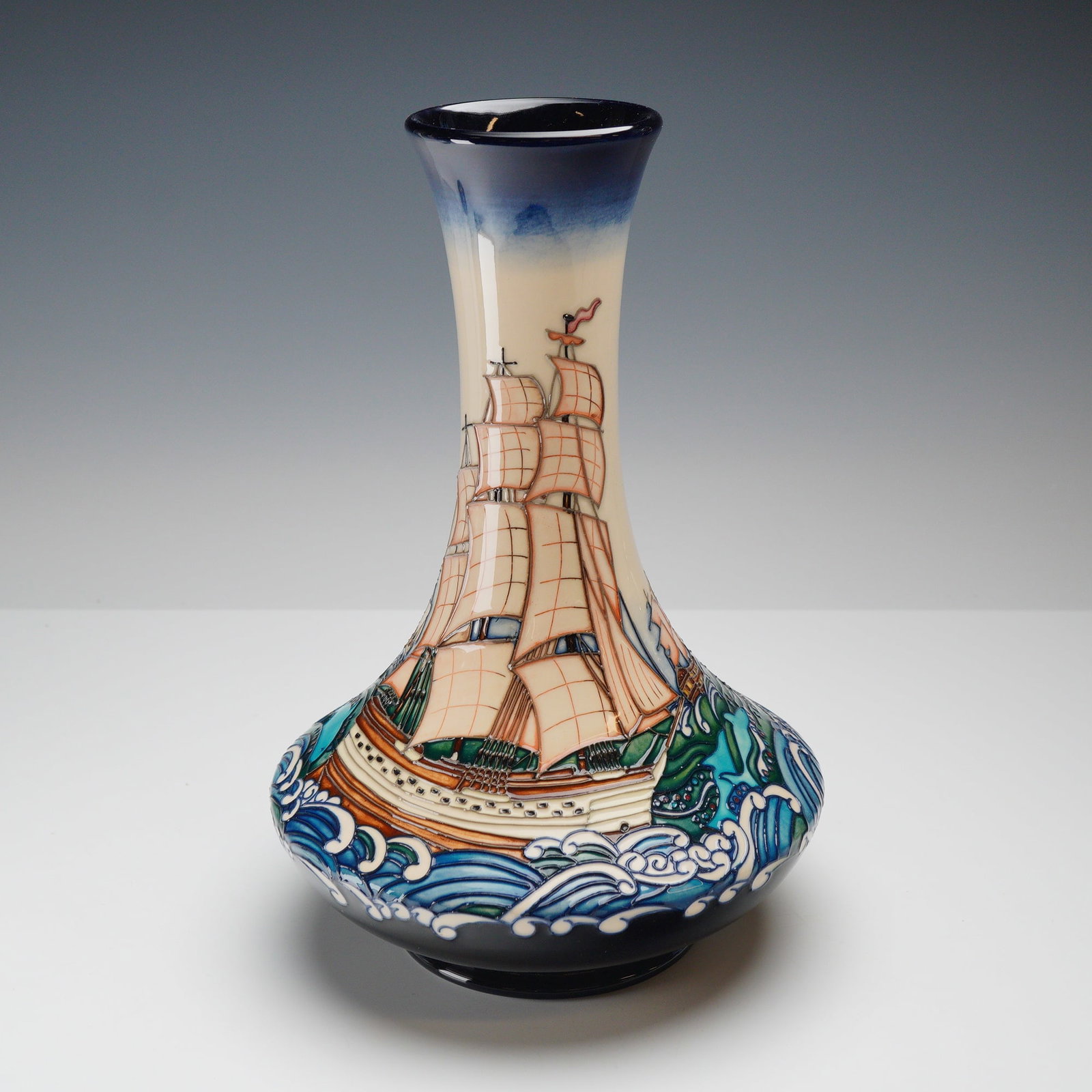 Moorcroft Earthenware Vase by Paul Hilditch, Launching Liberty Ship: This Moorcroft earthenware vase features the Launching Liberty Ship pattern designed by Paul Hilditch. The piece is decorated using the factory signature tubelining technique, where raised outlines of