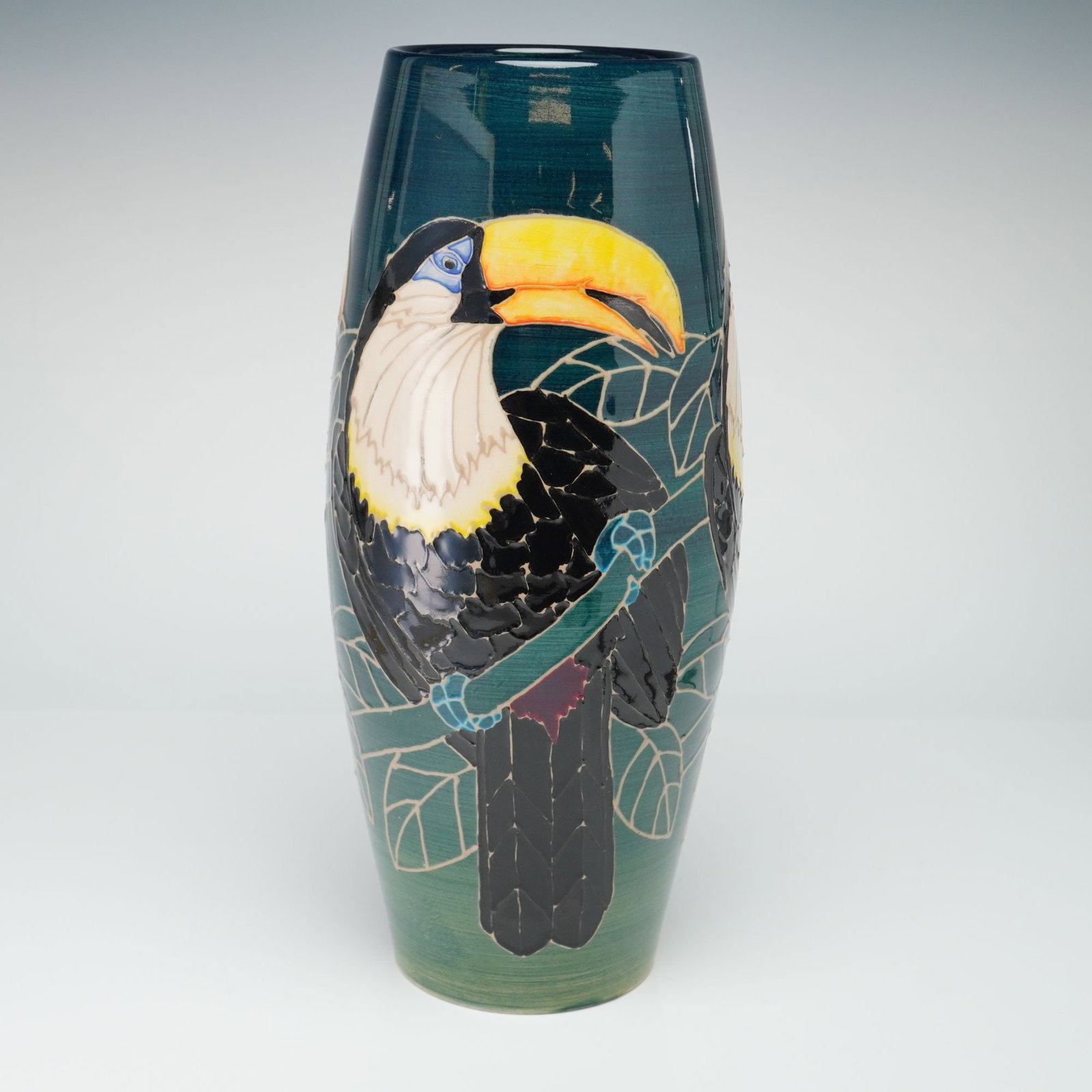 Dennis China Works by Sally Tuffin Vase, Toucan: The vessel is constructed in a tapering cylindrical form with a slightly bulbous midsection. The decoration is executed using hand-painted and tube-lined techniques, depicting toucans perched on branc