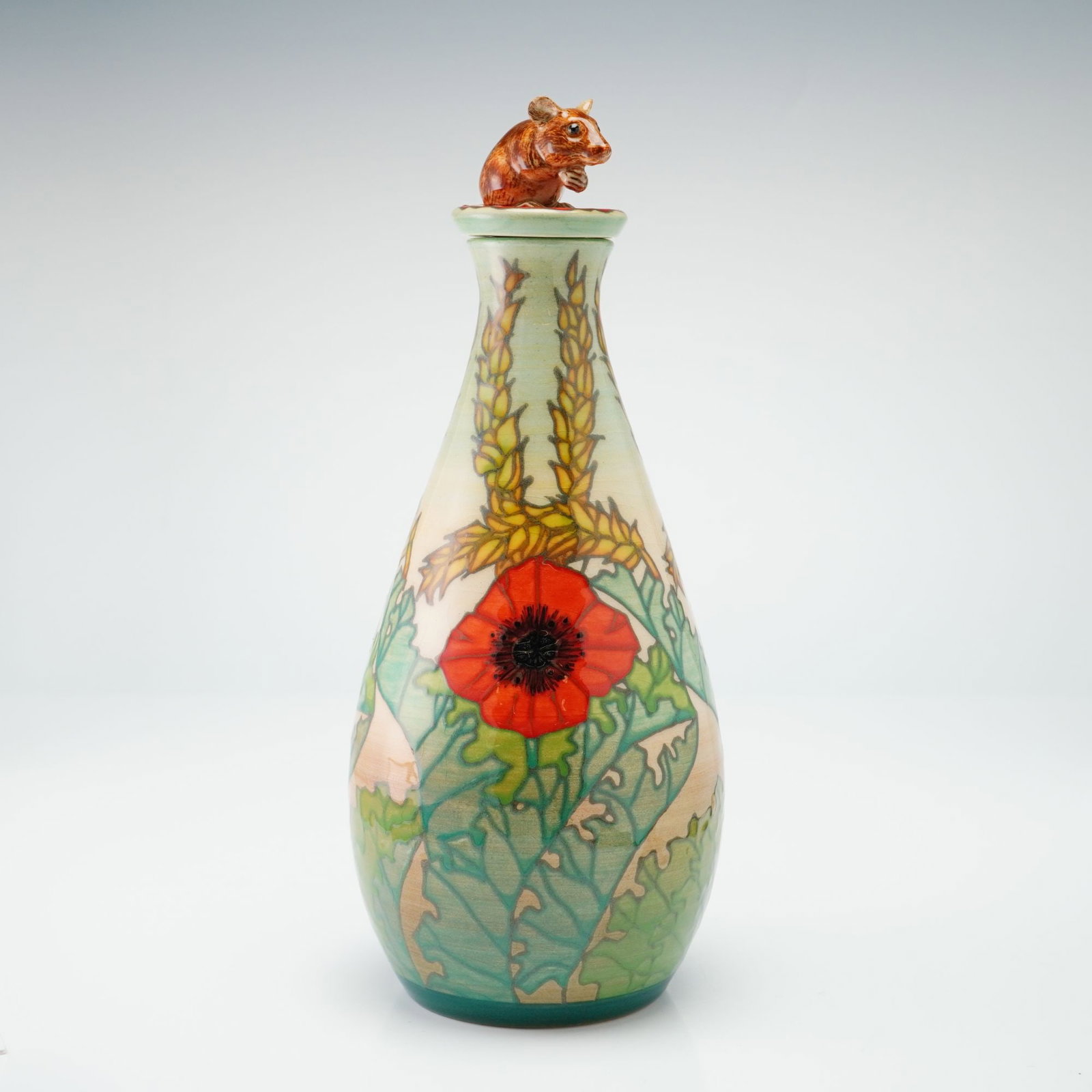 Dennis China Works Pottery by Sally Tuffin Mouse Lidded Vase, Corn and Poppy: The teardrop-shaped vessel is crafted using the tube-lining technique and hand-painted under a clear glaze. Its decoration features vibrant red poppies with black centers, broad green foliage, and upr