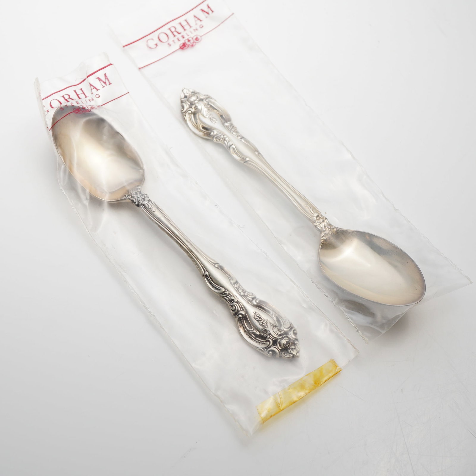 2pc Gorham Sterling Silver Dessert Spoons, La Scala: This pair of dessert spoons is manufactured by the Gorham Manufacturing Company in the La Scala pattern. The items feature a deeply carved, pierced handle decorated with elaborate scrollwork and a ros