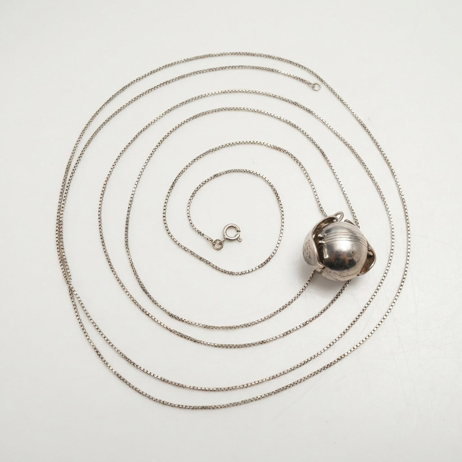 Sterling Silver Italian Necklace with Folding Sphere Pendant: This jewelry item consists of a 925 sterling silver folding sphere locket pendant. The pendant is constructed from several hinged segments that expand to reveal internal compartments. The pendant is s