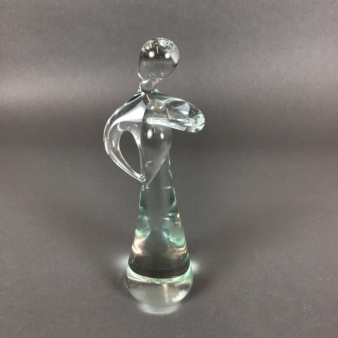 FM Ronneby Sweden Art Glass Mother and Child Sculpture: This stylized art glass sculpture represents a mother and child, featuring the fluid lines and minimalist form characteristic of mid-century Scandinavian modern design. The piece is crafted from solid