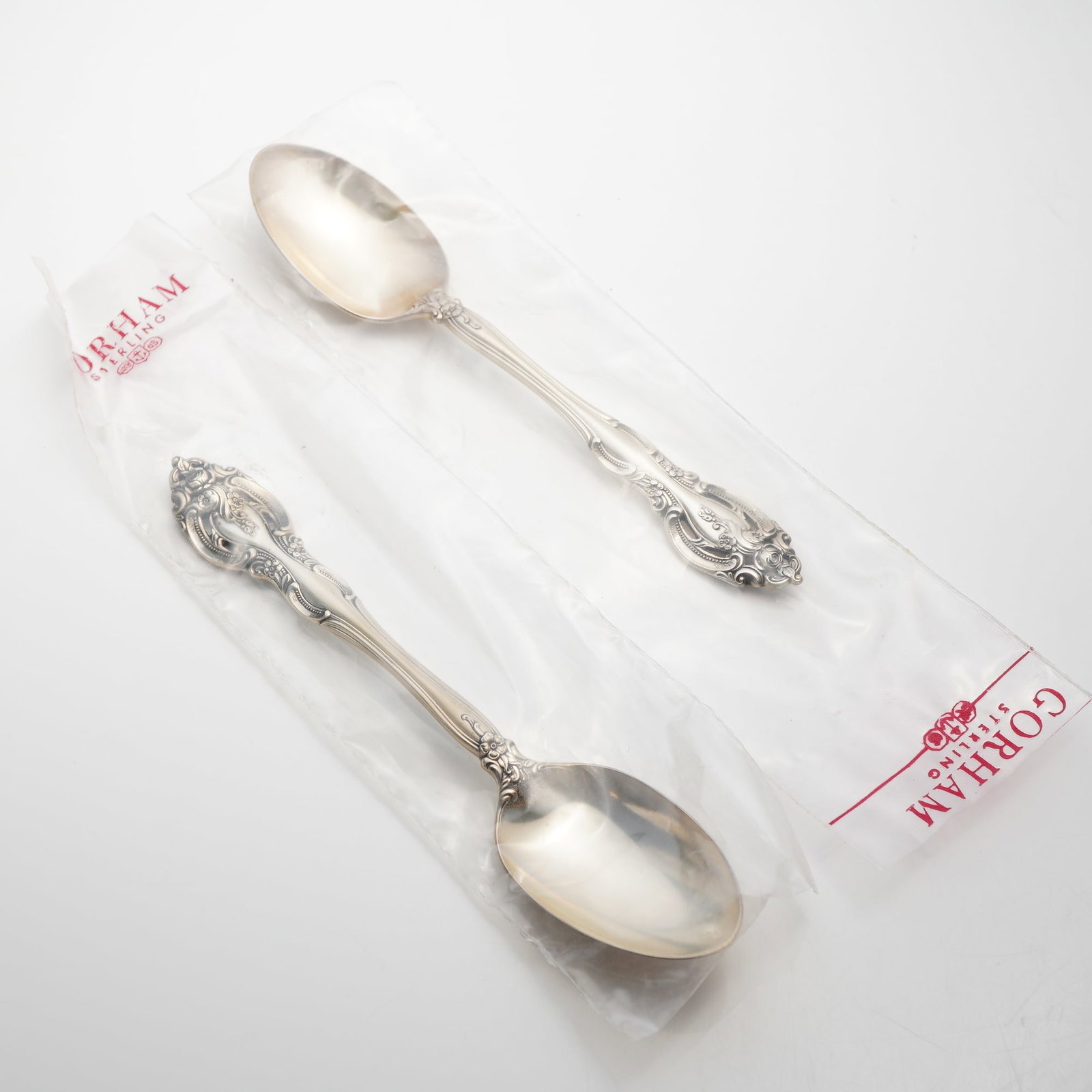 2pc Gorham Sterling Silver Dessert Spoons, La Scala: This pair of dessert spoons is manufactured by the Gorham Manufacturing Company in the La Scala pattern. The items feature a deeply carved, pierced handle decorated with elaborate scrollwork and a ros