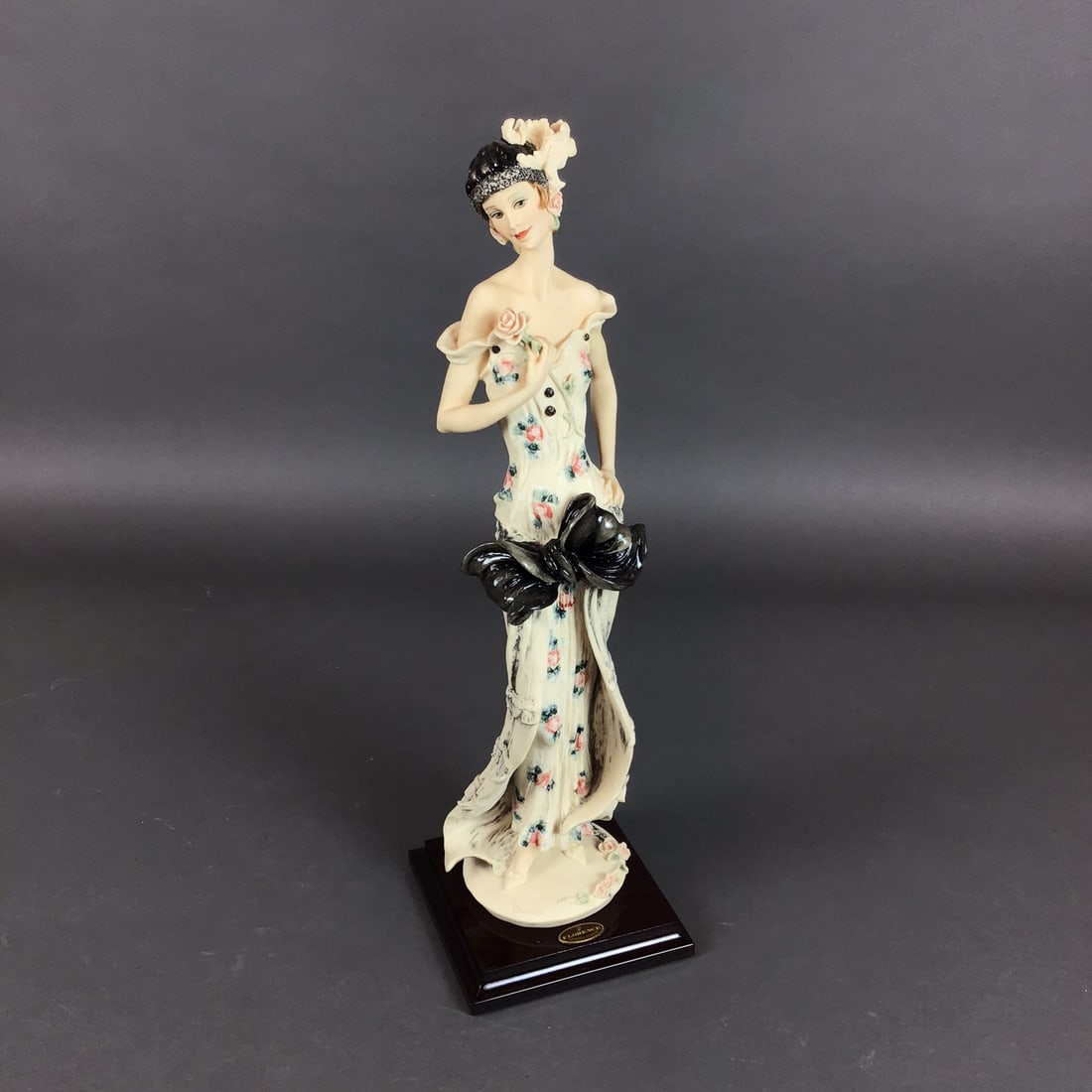 Giuseppe Armani Florence Sculture d'Arte Porcelain Sculpture, The Flirt: This authentic Giuseppe Armani sculpture, titled The Flirt, was produced by the Florence Sculture d'Arte studio in Italy. The piece is crafted from cold-cast porcelain and mounted on a dark-finished s