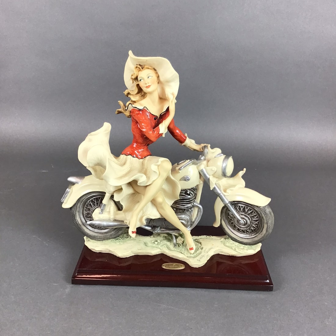 Limited Edition Artist Proof Giuseppe Armani Florence Porcelain Figurine, On The Road: This hand-painted figurine, titled On The Road, was created by Italian sculptor Giuseppe Armani for Florence Sculture d'Arte. The sculpture depicts a woman wearing a wide-brimmed hat and a red blouse,