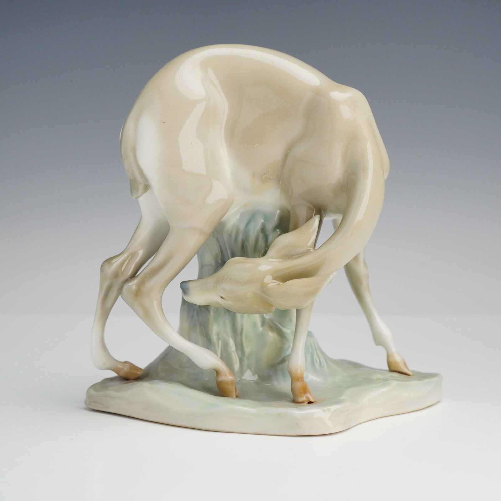 Lladro Glazed Porcelain Figurine, Gazelle Deer 1000327.13: This rare piece depicts a gazelle in a dynamic grooming pose with its head turned back toward its flank. The figure is modeled with slender limbs and is set upon an integral rocky base. The palette fe