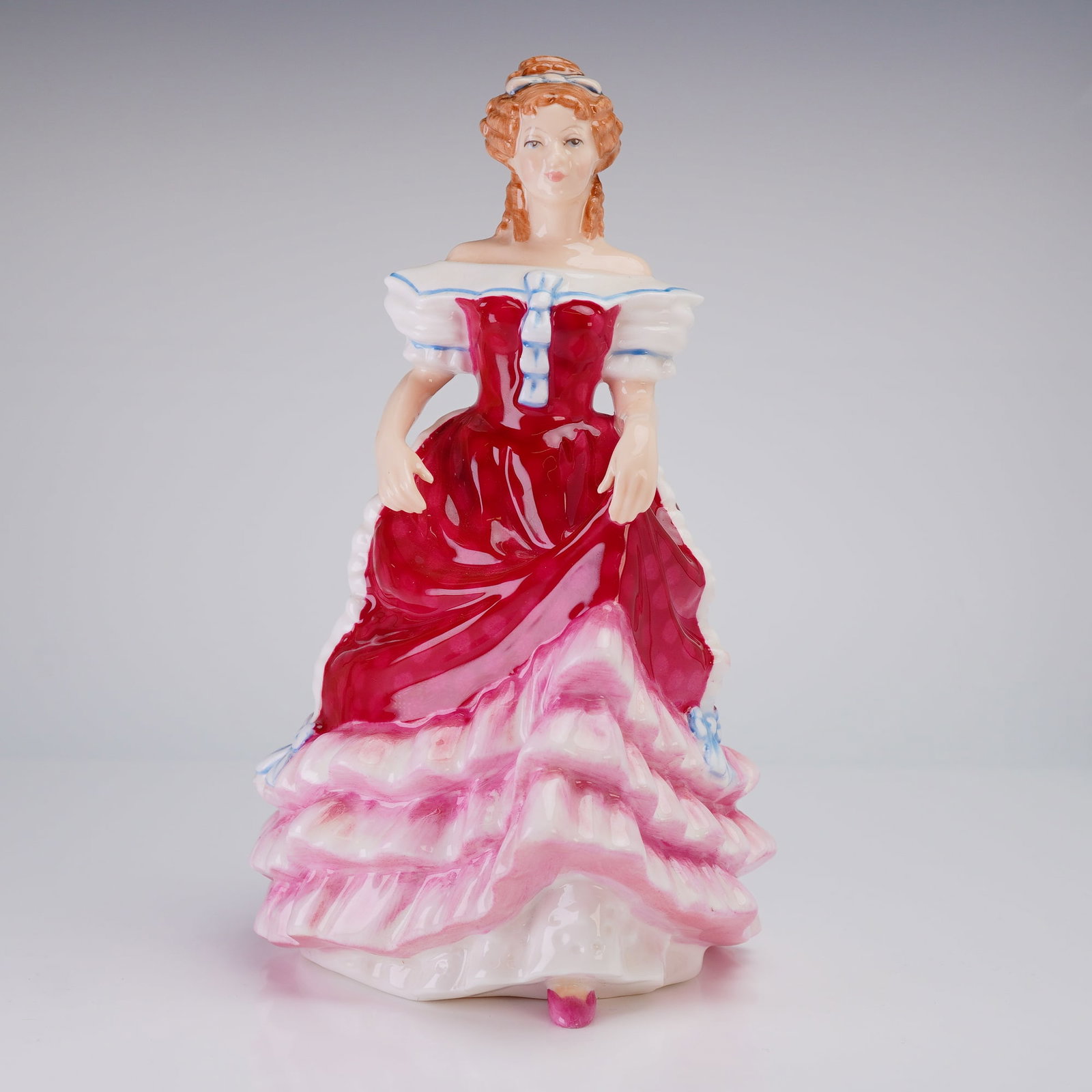 Royal Doulton Sweet Sixteen HN 3648 Bone China Figurine: Royal Doulton Bone China Figurine, Sweet Sixteen (HN3648), depicting a woman in a red, pink, and white ruffled dress, copyrighted 1994 and inscribed Marcia de Pedeley. Dimensions: 4.50"L x 5.25"W x 8.