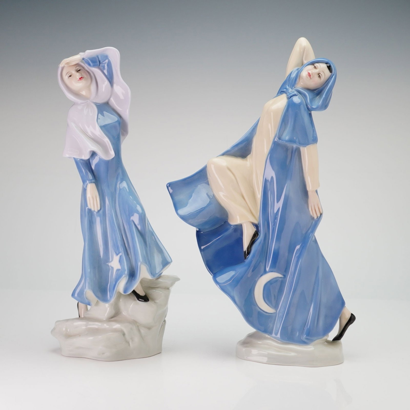 2pc Royal Doulton Reflections Figurines, Stargazer HN 3182 and Moondancer HN 3181: A group of porcelain figurines from the Reflections series by Royal Doulton, both designed by Douglas V. Tootle and issued in 1988. The first figurine, titled Stargazer (HN 3182), depicts a woman in f