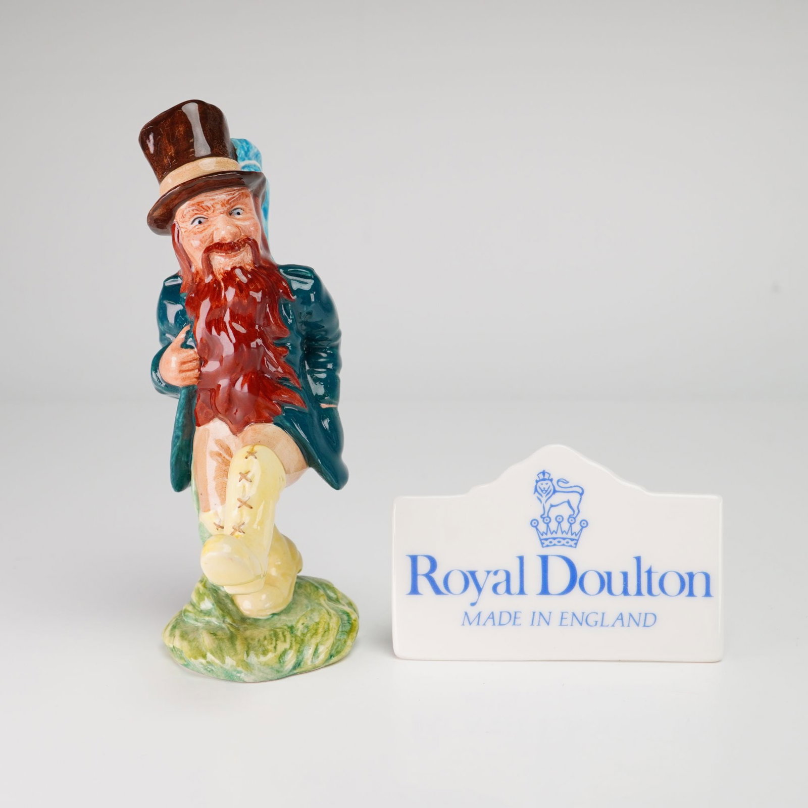 2pc Royal Doulton Middle Earth Tom Bombadil Figurine HN 2924 and Plaque: A Royal Doulton polychrome glazed porcelain figurine titled Tom Bombadil, model number HN 2924, from the Middle Earth collection. The figure depicts the character from J.R.R. Tolkien literature in a d