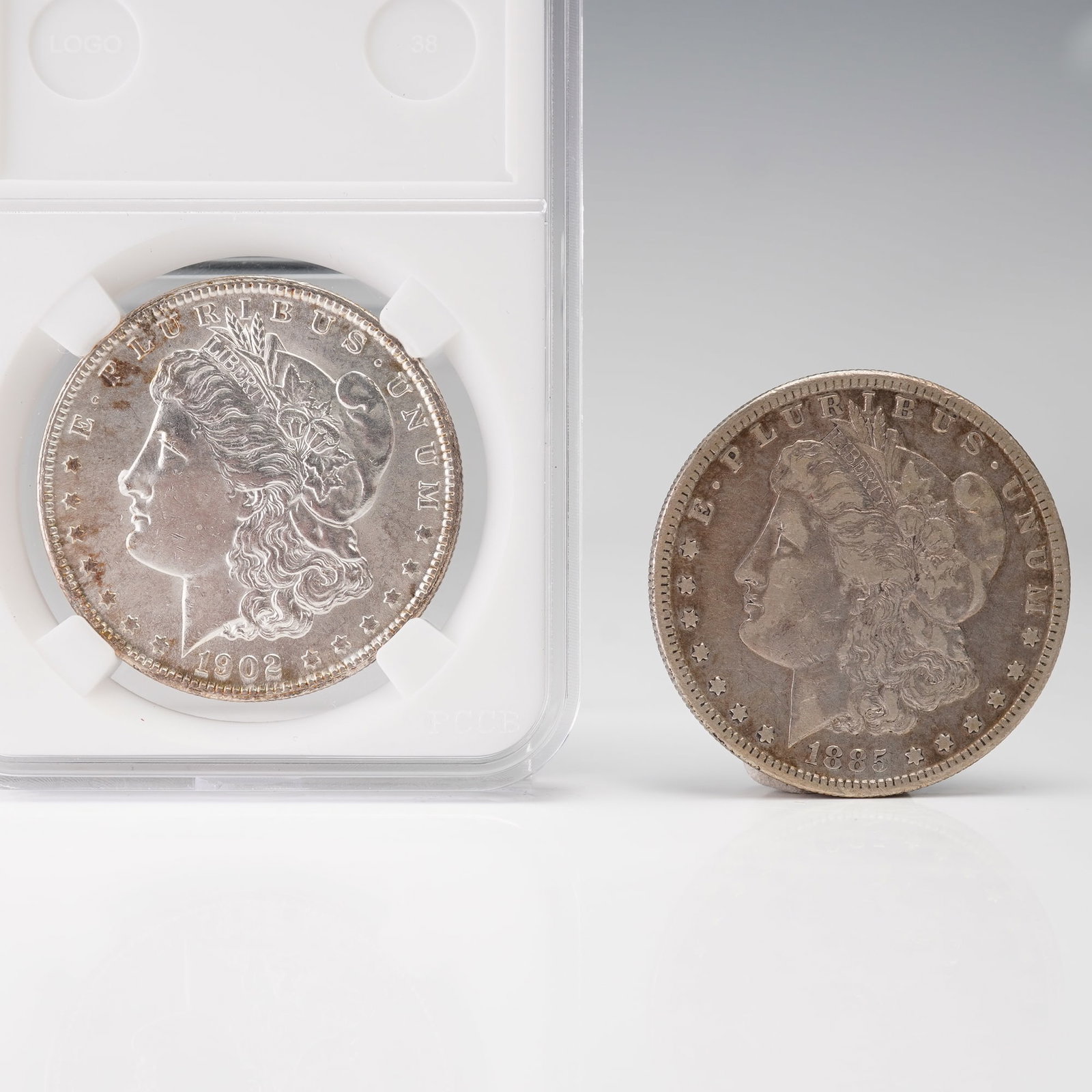 2pc 1885-S to 1902-O Morgan Silver Dollar Coins: Each coin features the classic Liberty head design on the obverse, surrounded by the inscription E PLURIBUS UNUM with the date below. The reverse depicts a heraldic eagle with outstretched wings clutc