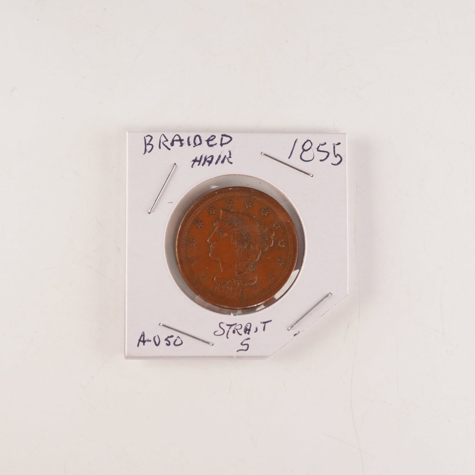1855 Liberty Braided Hair One Cent Coin: The obverse portrait of Liberty wearing a coronet inscribed with her name, encircled by thirteen stars, and the year below. The reverse bears a wreath surrounding the denomination ONE CENT. Composed o